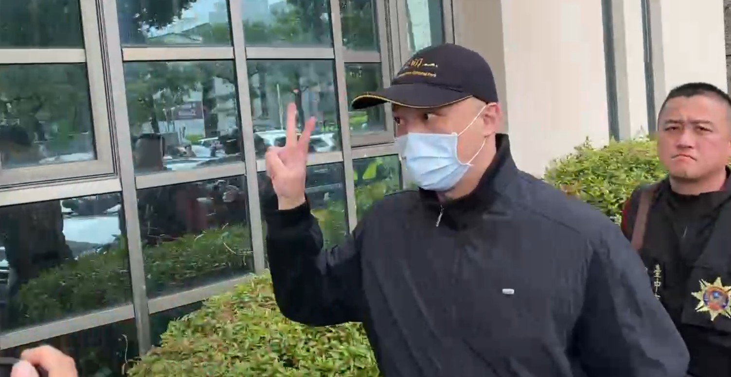 夏男在媒體簇擁下、比出「YA」勝利手勢。