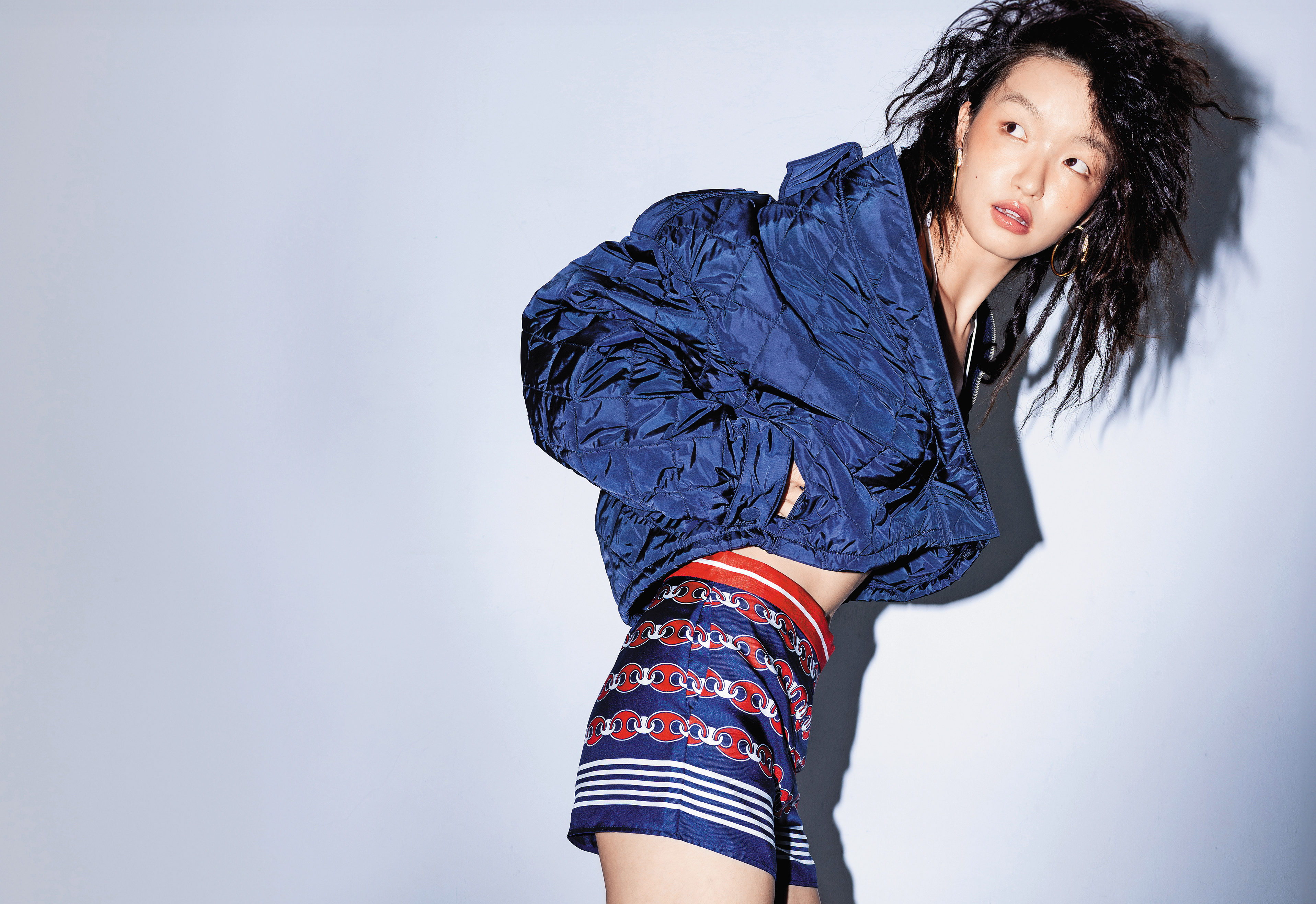 深藍色再生尼龍夾克  價格店洽by PRADA／紅色絲質短褲NT$47,500 by GUCCI／Dextera大圈耳環NT$9,500 by SWAROVSKI