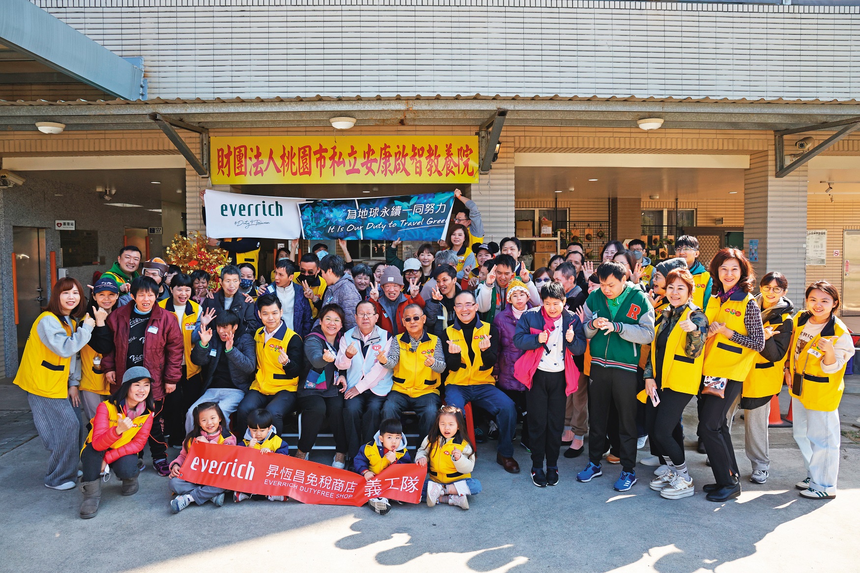 昇恆昌董事長江松樺與公司同仁志工、教養中心的院生們一起大合照，開心喊出新年快樂，共同迎接美好的一年到來。(昇恆昌免稅店提供)