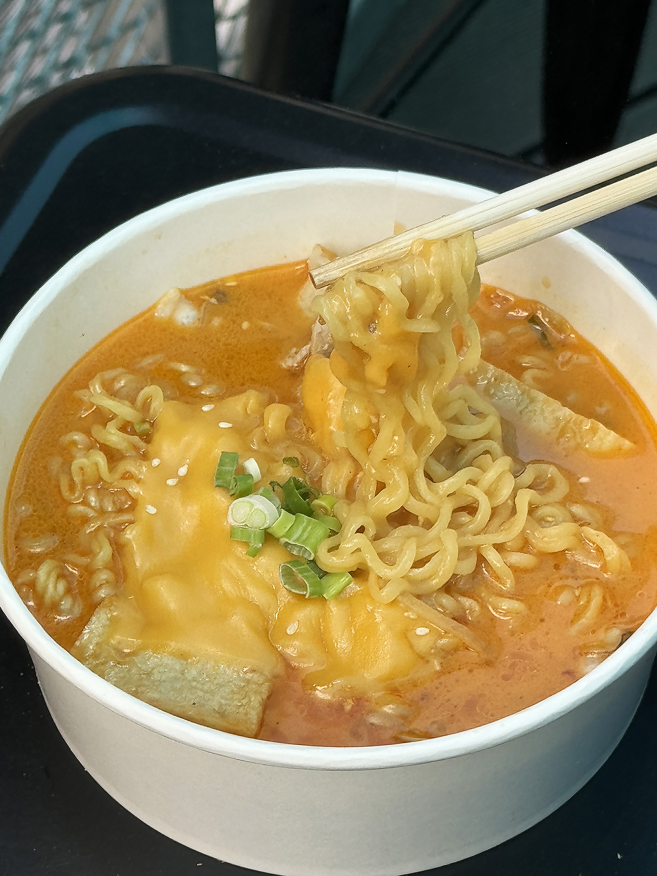 「樂雞起司拉麵」加入魚板、蛤蠣與五花肉等韓國常見食材,為帶有微辣甜感的湯頭增加鮮甜滋味。(180元/份)