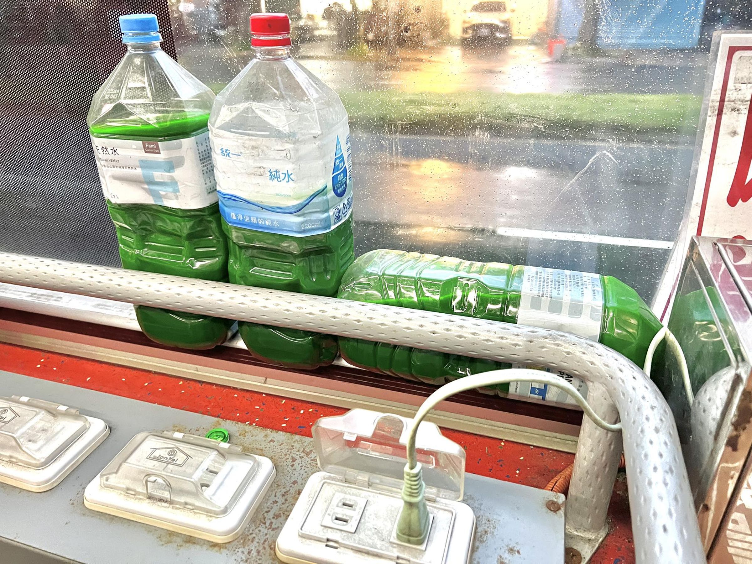 一名網友日前搭公車內放著3罐綠色液體,好奇發問有何用途。(翻攝臉書「路上觀察學院」)