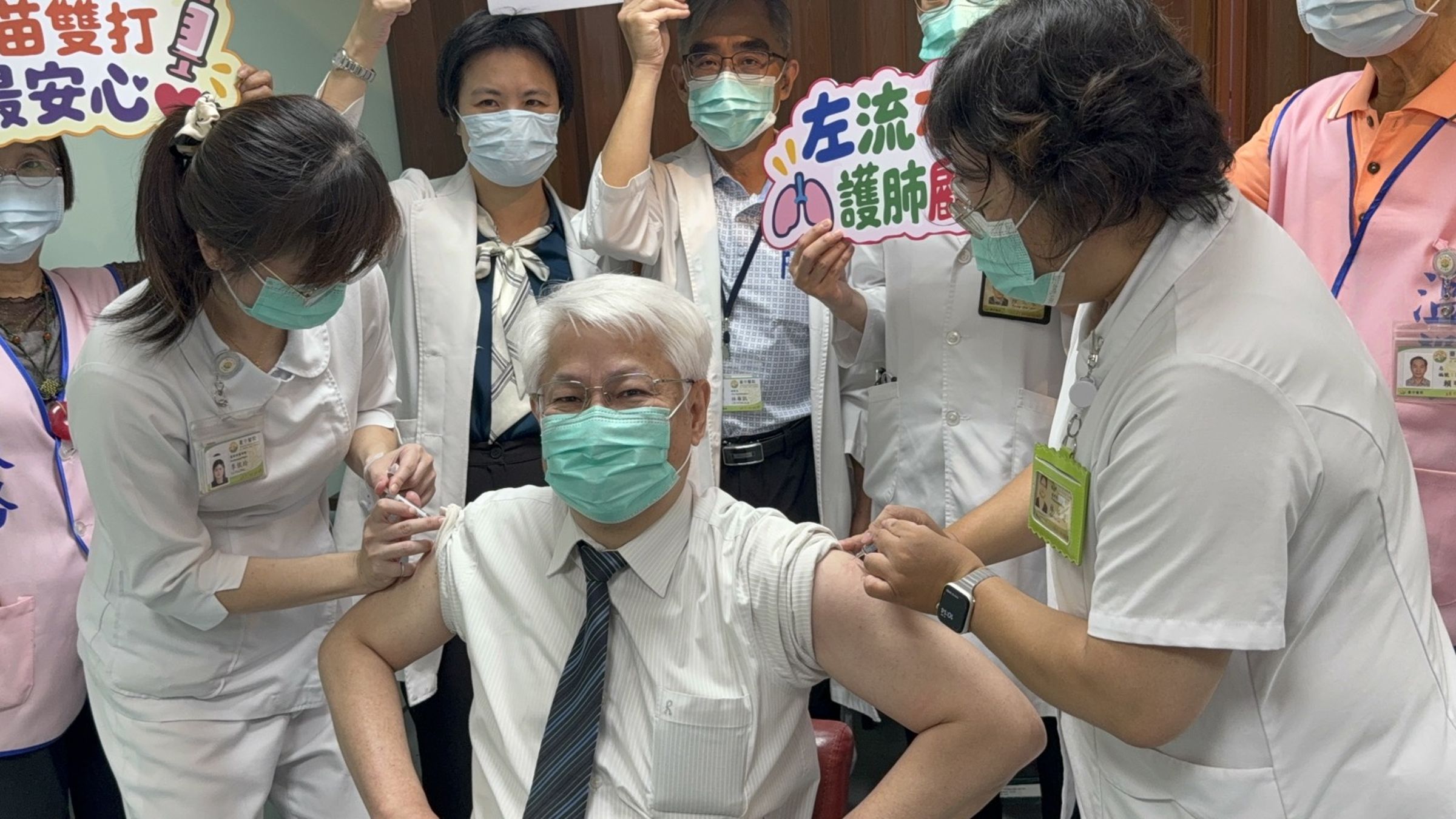 衛生福利部臺中醫院黃元德院長(前中)獻出雙臂示範同步接種流感與新冠雙疫苗。(院方提供)