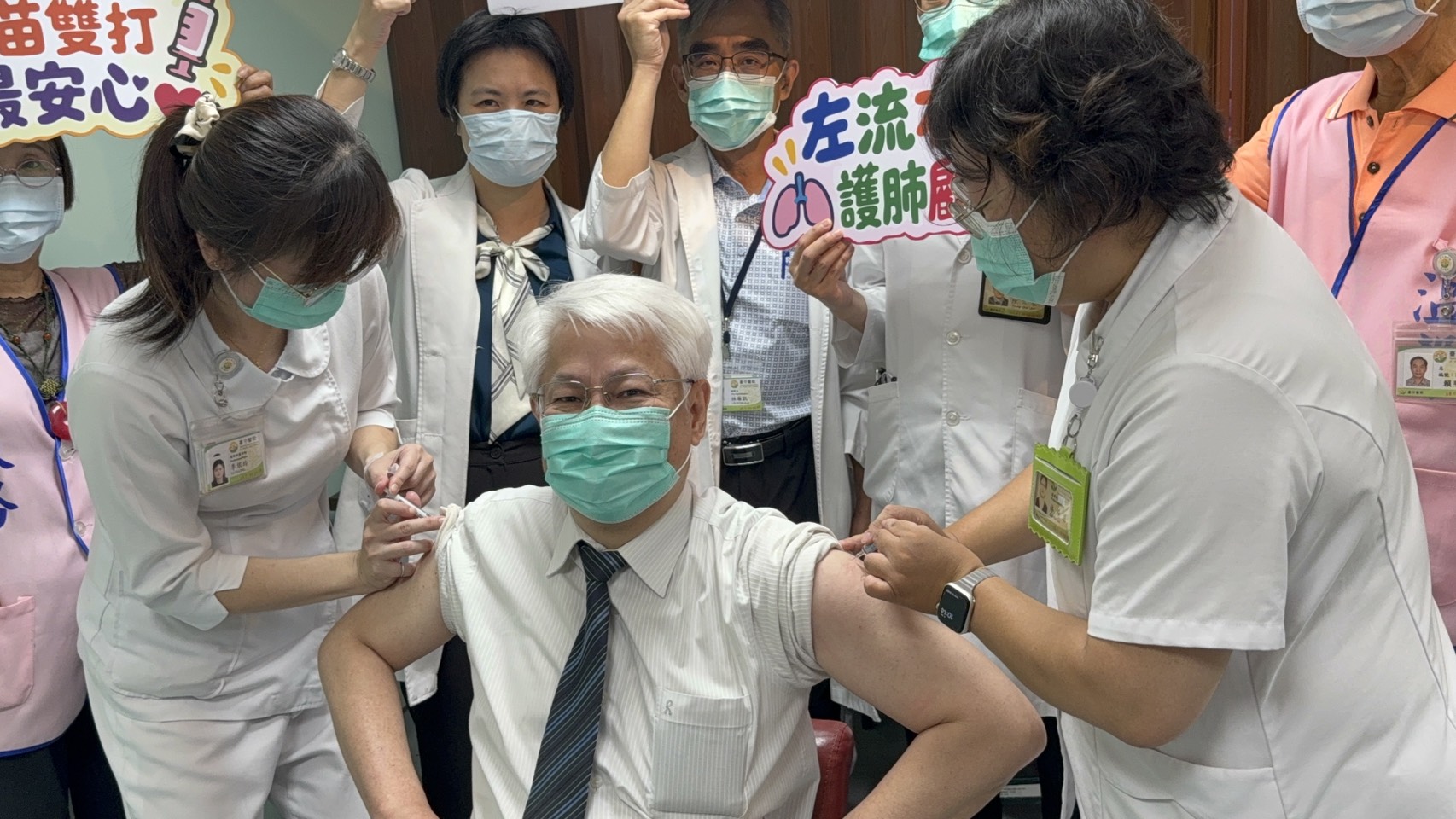 衛生福利部臺中醫院黃元德院長(前中)獻出雙臂示範同步接種流感與新冠雙疫苗。(院方提供)
