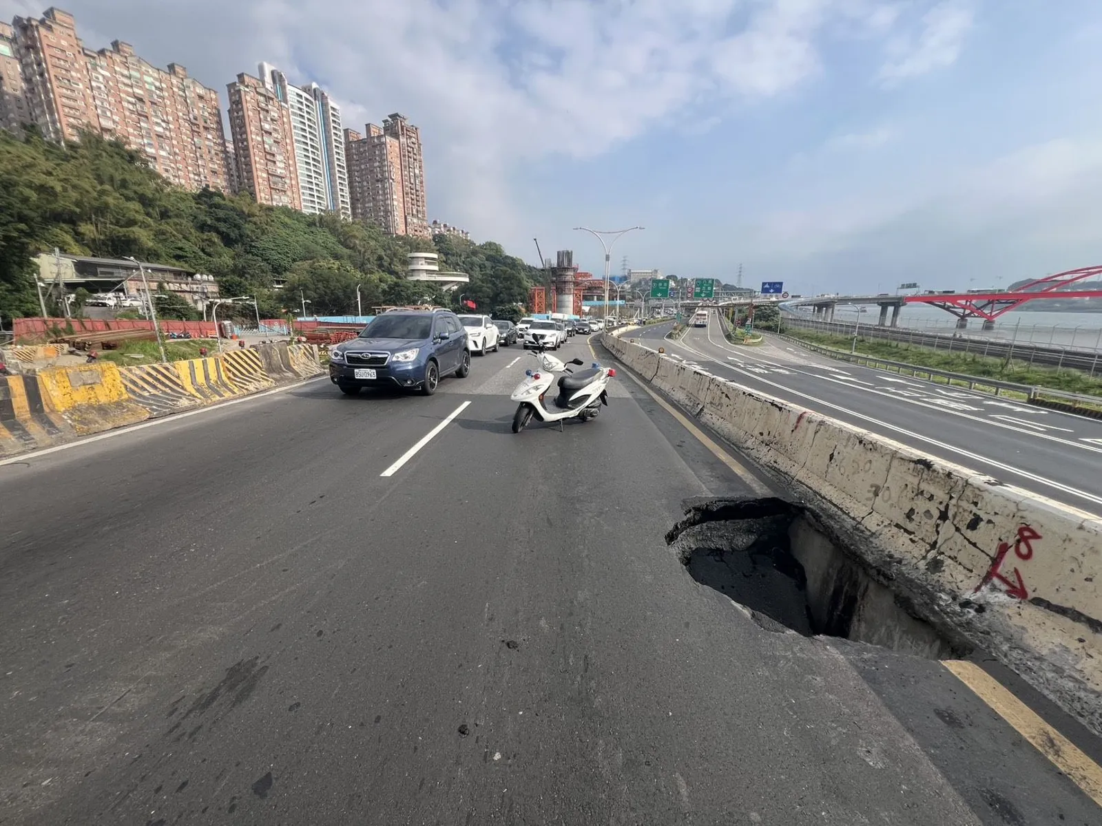 新北市淡水區民權路台北往淡水方向中央分隔島內側車道出現一處坑洞，深約1公尺。（翻攝畫面）