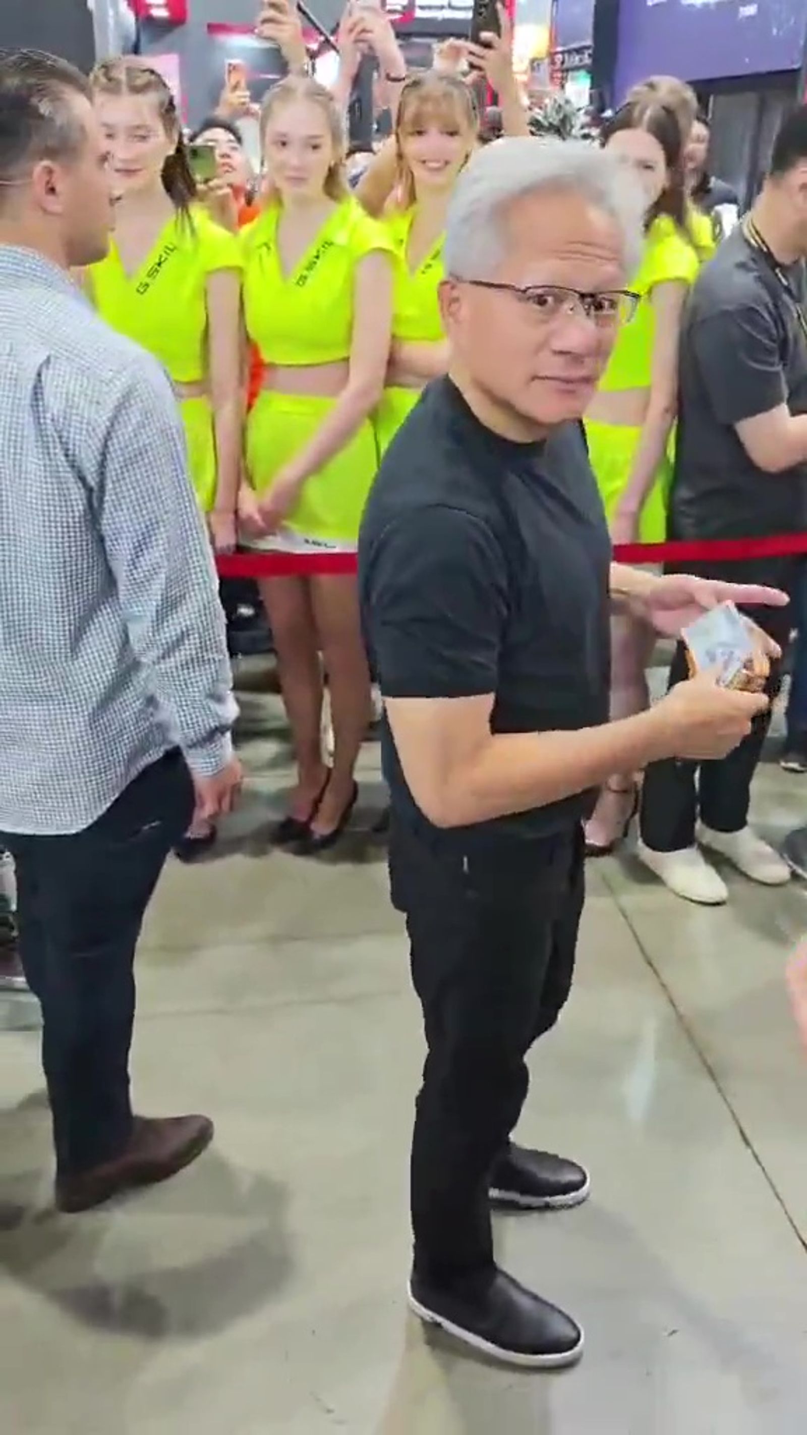 黃仁勳拿出千元鈔票，簽名前看了一下皮夾的主人，表情相當逗趣。（翻攝hkepc Threads）
