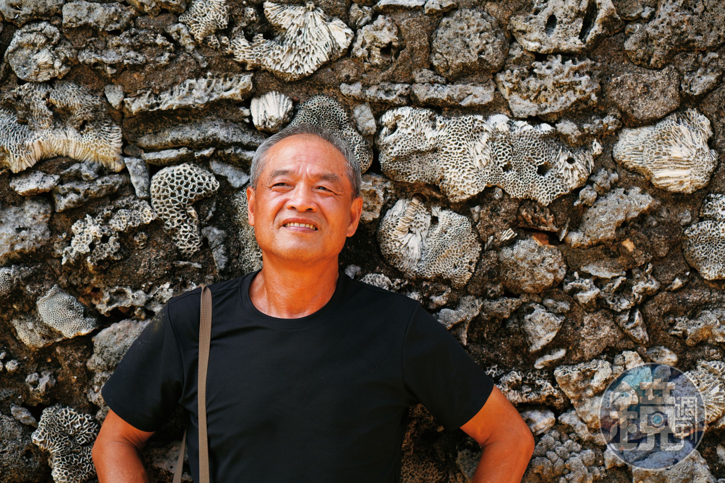 謝三泰在澎湖傳統建築的咾咕石牆前。澎湖曾是他一心逃離的地方，卻也是漂泊異鄉四十多年後想回返的原鄉。