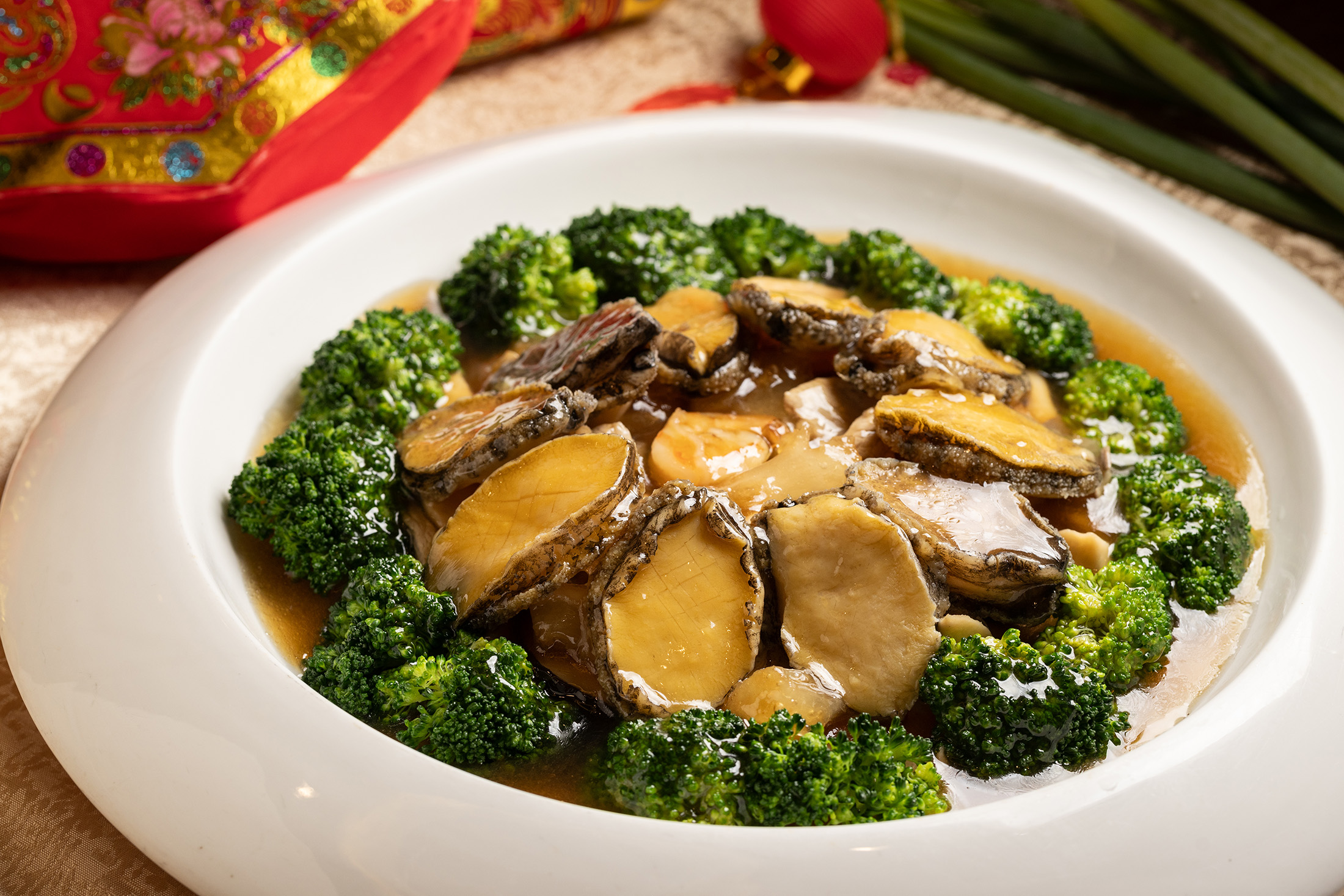 「原粒蠔皇煨鮑魚」淋上鮮美蠔油醬汁，既能吃到鮑魚的彈牙，還能品嘗花椰菜的清脆。（9,800元／10人桌菜）