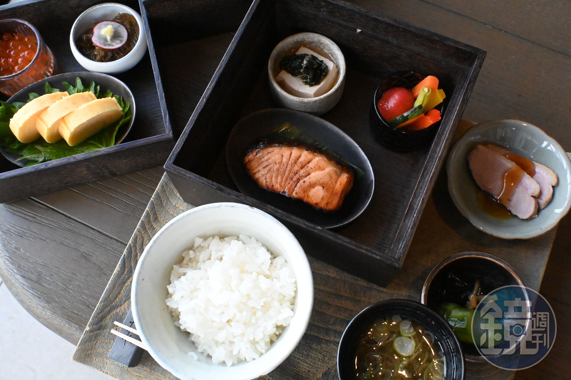 NAGI的日式早餐「Japanese」包含烤鮭魚、時令燉蔬菜、日式玉子燒搭配蘿蔔泥、花生豆腐佐柴魚片、黑醋海藻（もずく）、醃漬蔬菜等多道小菜，搭配白飯與味噌湯。（日幣8,000元／份，約NT$1516）