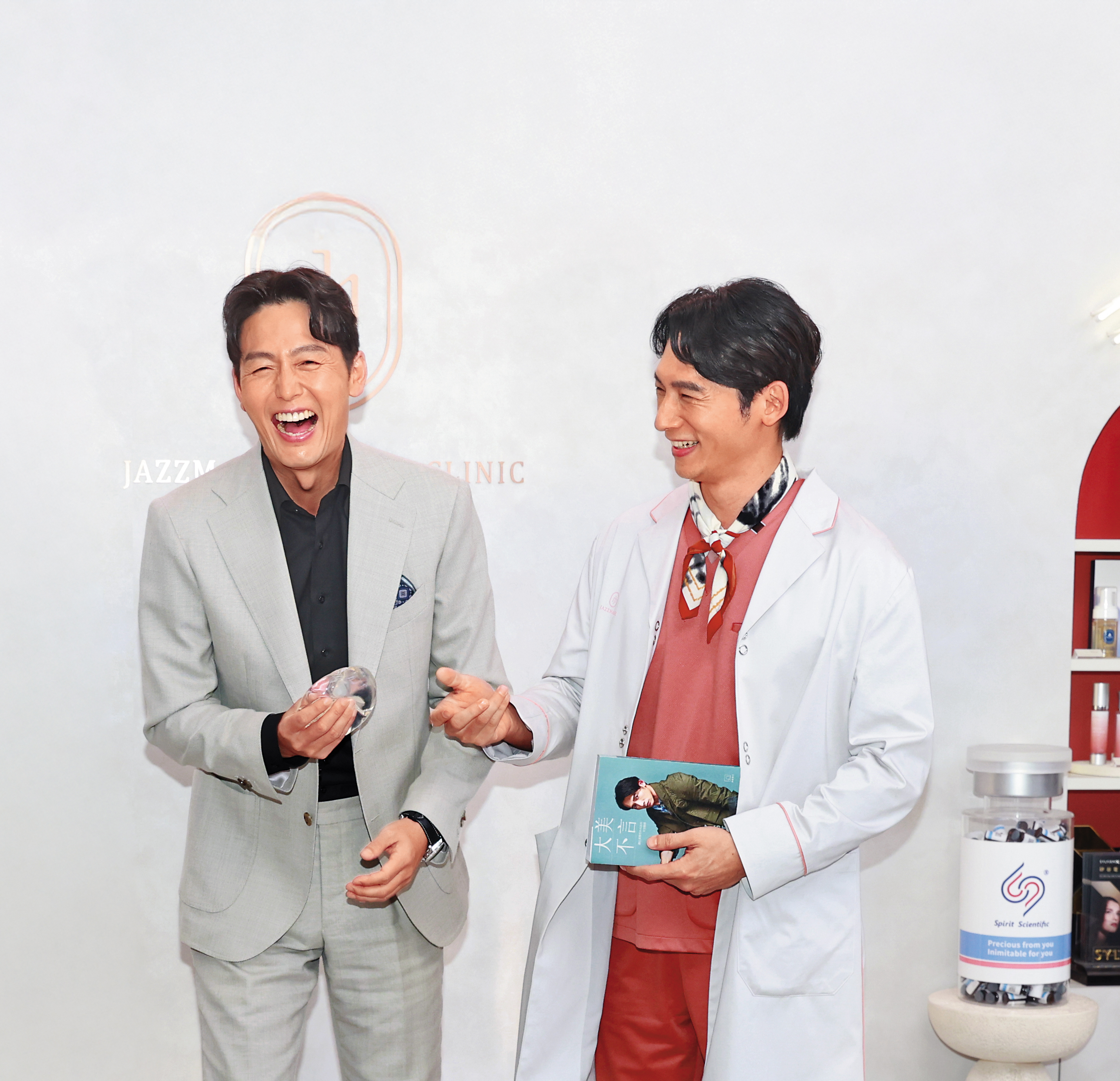 韓星李廷鎮（左）從温昇豪（右）手中接過隆乳假體，笑到美叮美噹。
