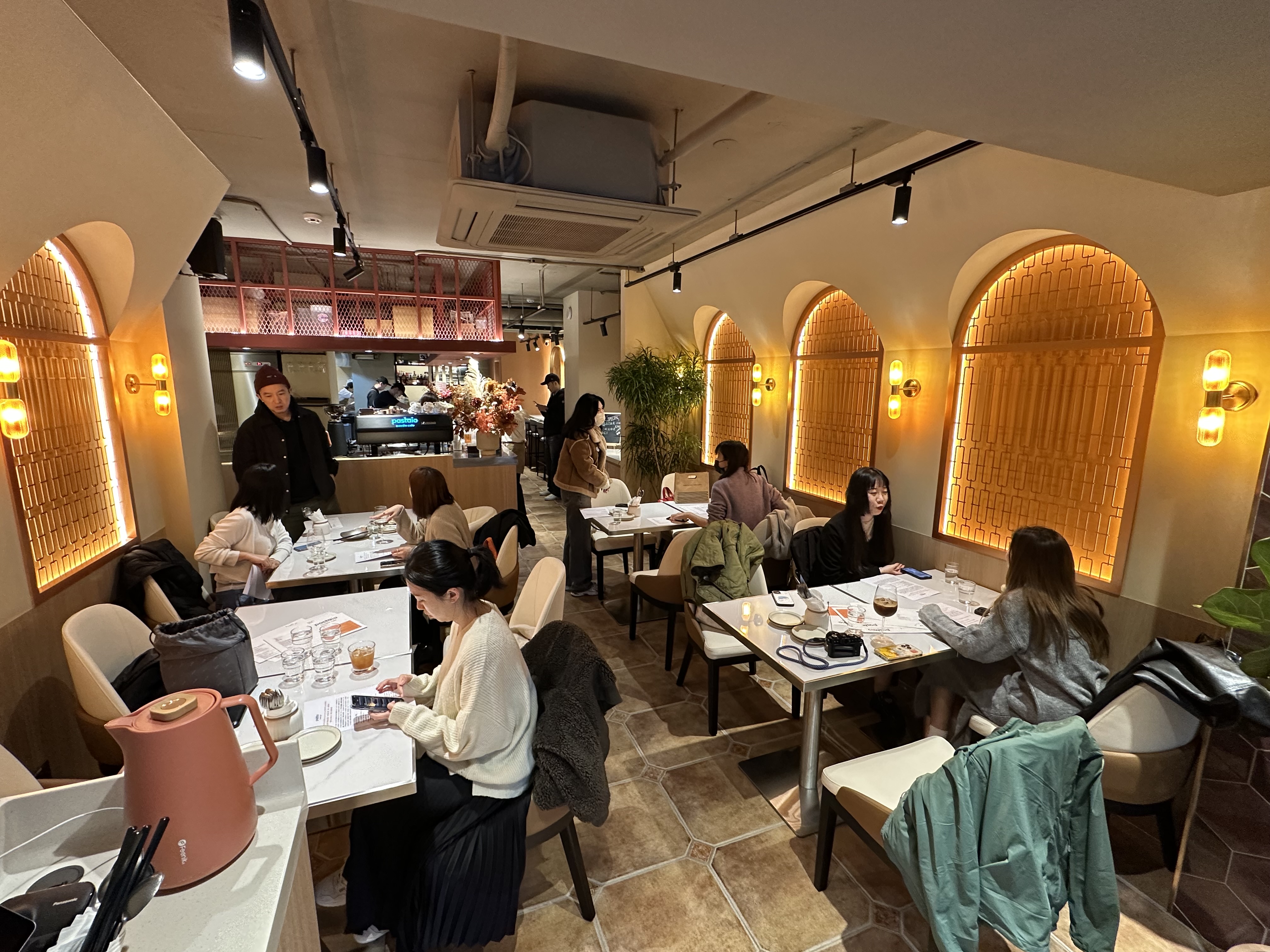 店內以圓拱元素，搭配大理石桌和植栽，營造簡約時尚風。