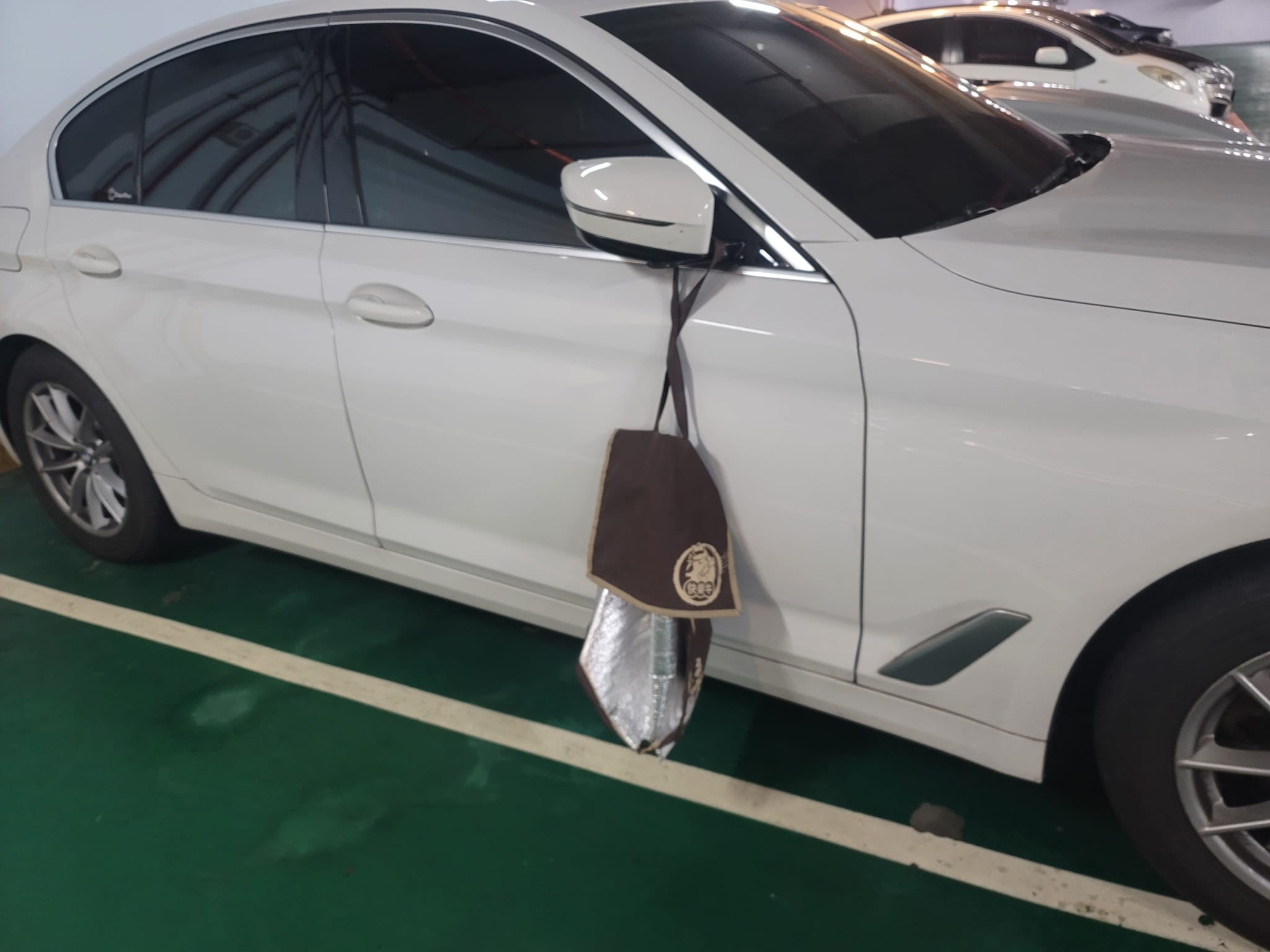 許秉毅開車前往台南開會時，在國道上竟有一個咖啡色保溫袋天外飛來卡在後視鏡上。（翻攝許秉毅臉書粉專）