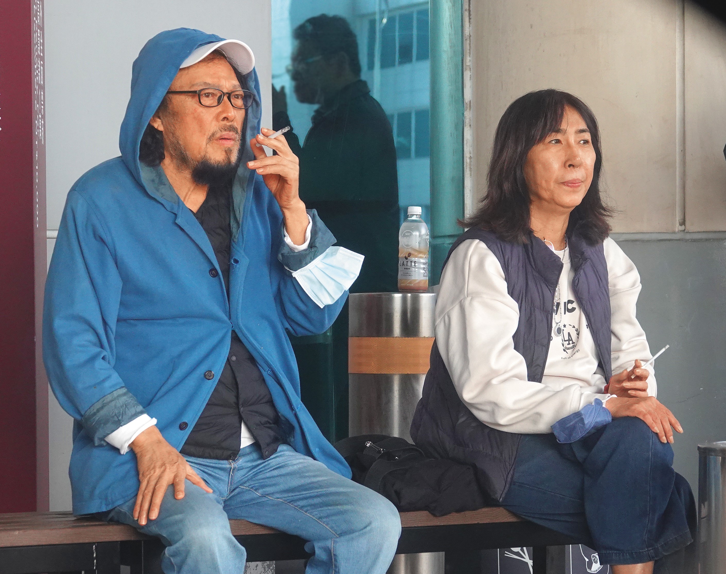 12月11日15：08，張菲（左）和慧姐（右）一下飛機立刻吞雲吐霧了好一陣子。