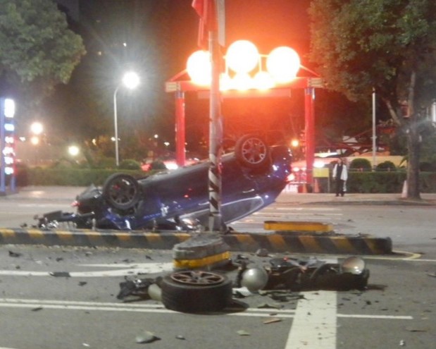 台中市一名女子今日凌晨酒後駕駛名車,自撞分隔島後翻覆,場面一片狼藉。(翻攝畫面)