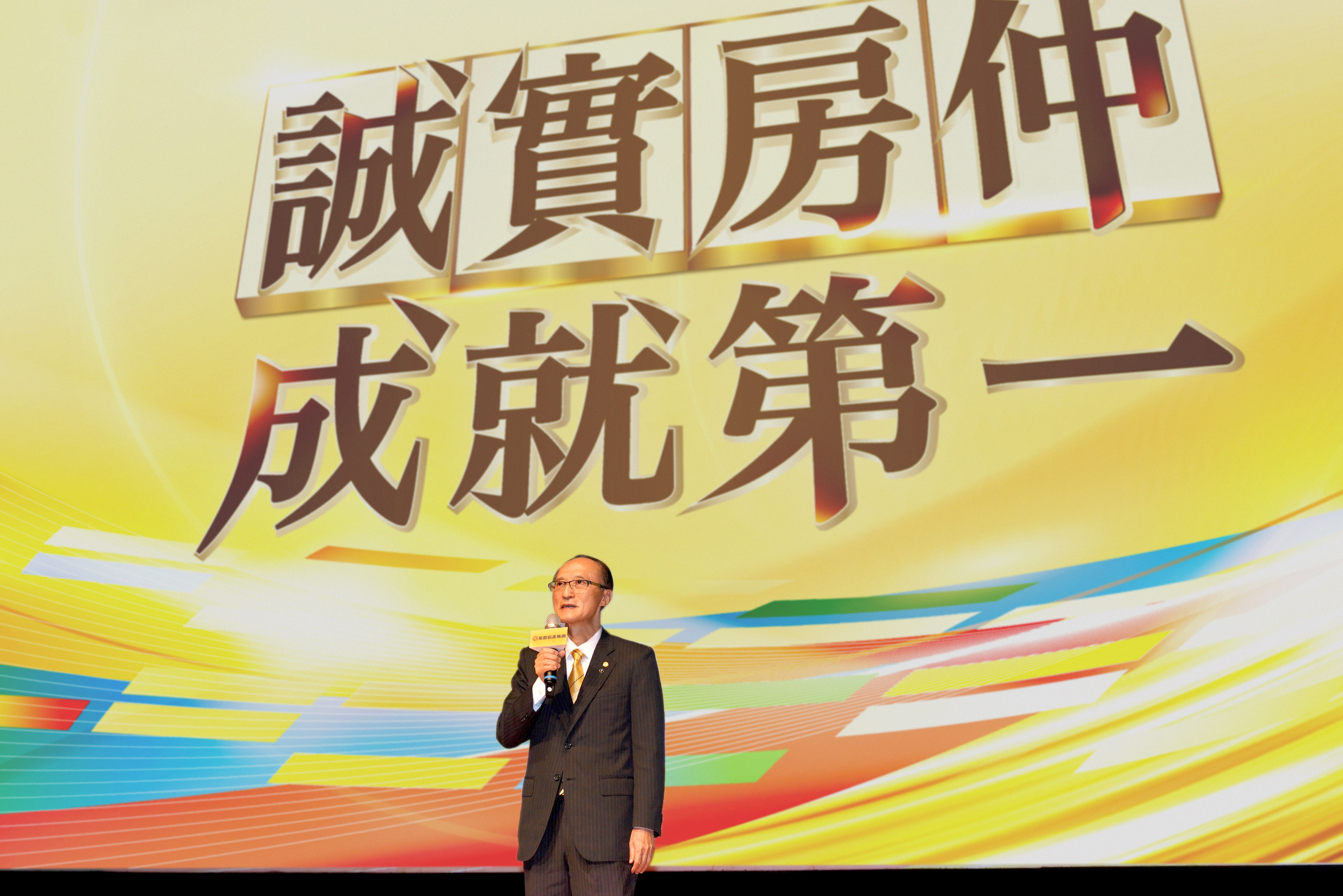 在「菁英會頒獎典禮」上，永慶房產集團董事長孫慶餘勉勵在場店東學習周文惠，培養兒子女兒接棒經營。（永慶房產集團提供）