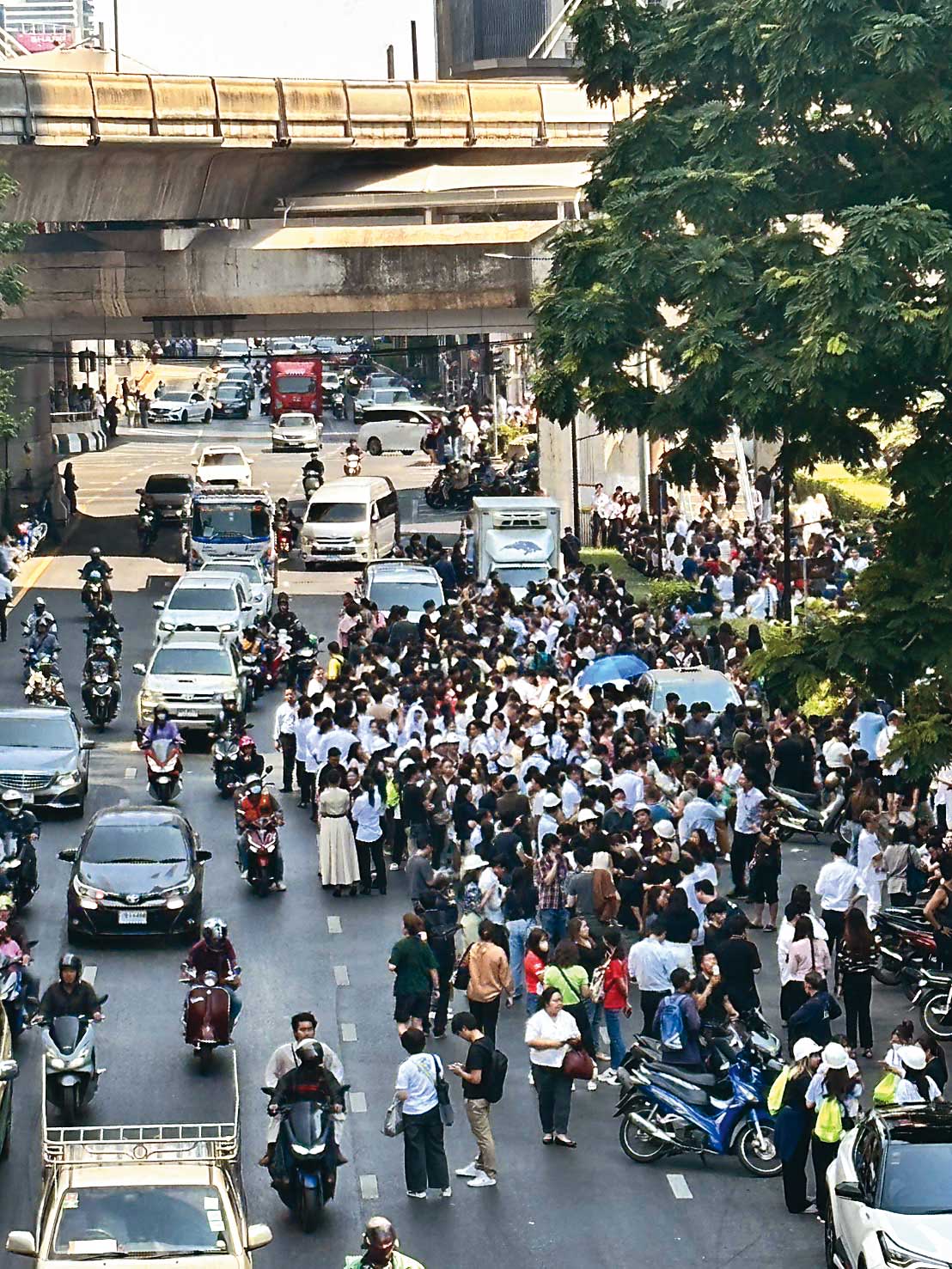 強震過後，曼谷民眾紛紛逃出屋外避難，難掩驚恐。（讀者提供）