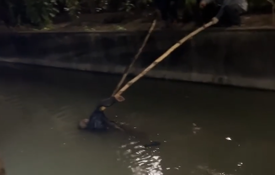 熱心民眾靠2根長竹竿防止老翁沉入水中。（翻攝臉書社團「大寮在地人大小事」）