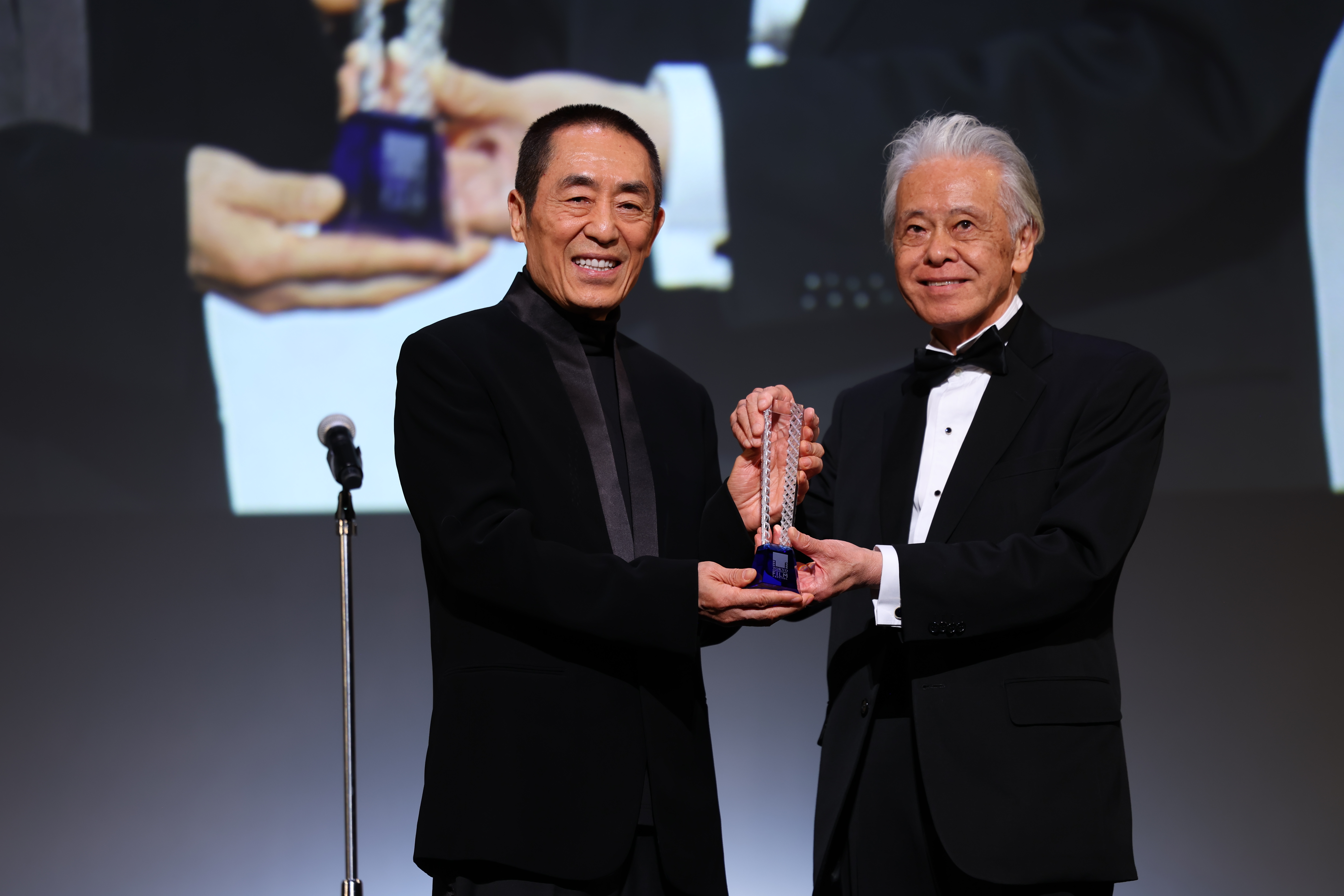 安藤裕康(右)在開幕典禮上頒發特別貢獻獎給中國導演張藝謀。(東京國際影展提供)