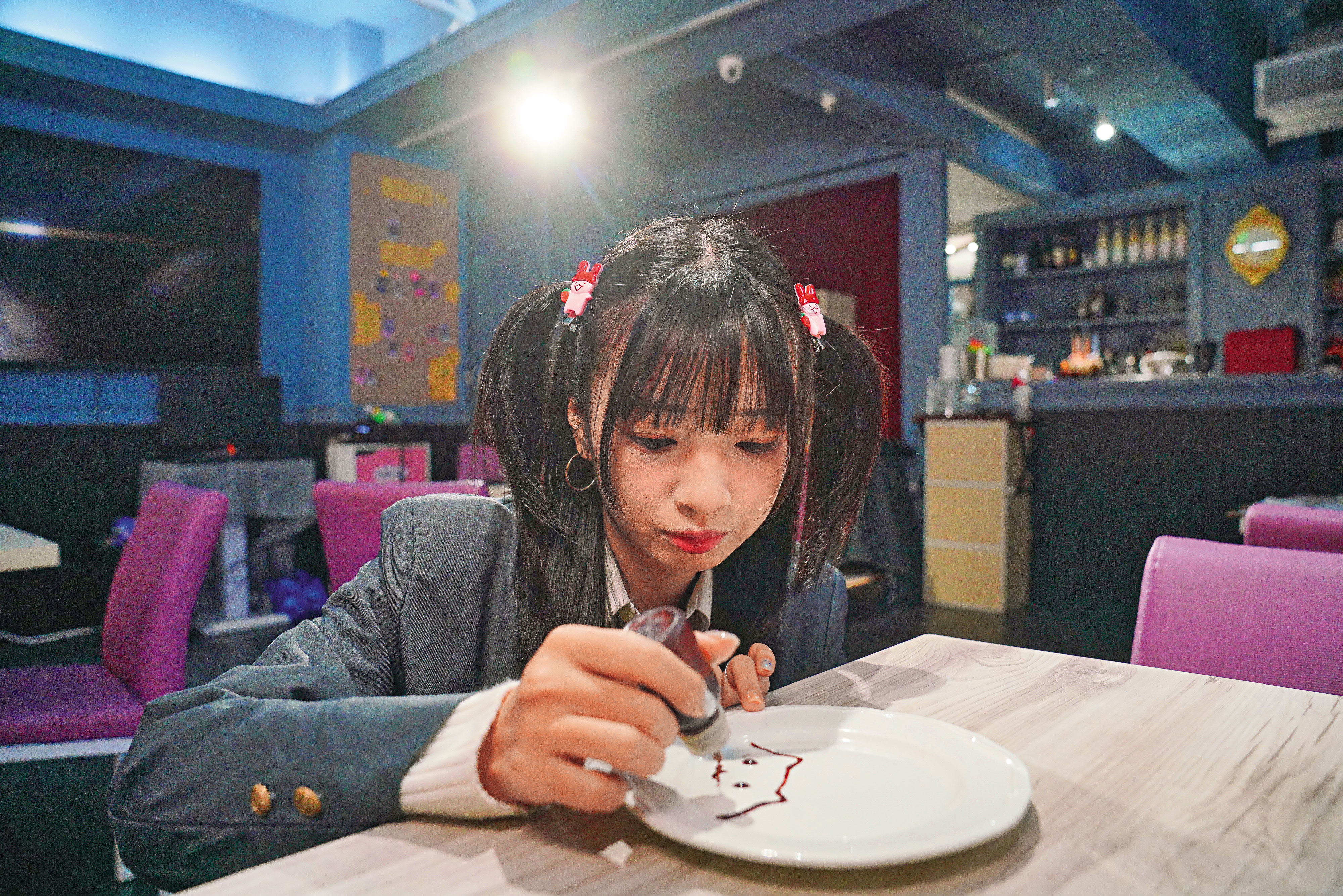 女僕咖啡廳的一大特色就是「繪盤」，由女僕在桌邊用巧克力醬繪製圖案。女僕繪盤蛋糕（150元/份）、心桃文學部（150元/杯）。