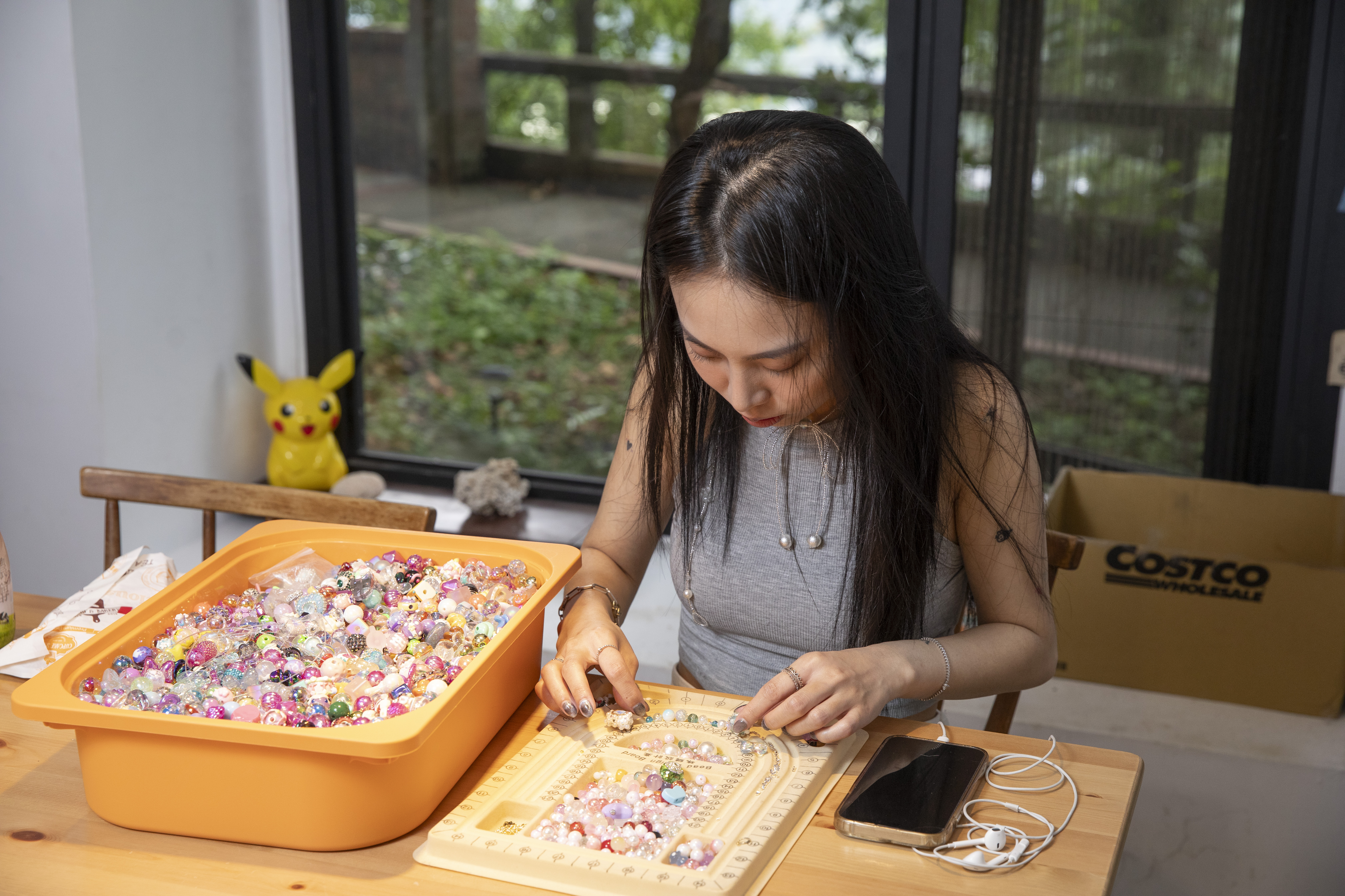 陳瑾緗專注地製作串珠手鍊,她每天可做10條,每條的顏色、細節都不一樣。