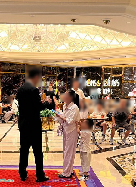 闖禍的男童母親與工作人員現場進行協商,男童瑟縮躲在媽媽身後。(翻攝.threads@lazytuba)