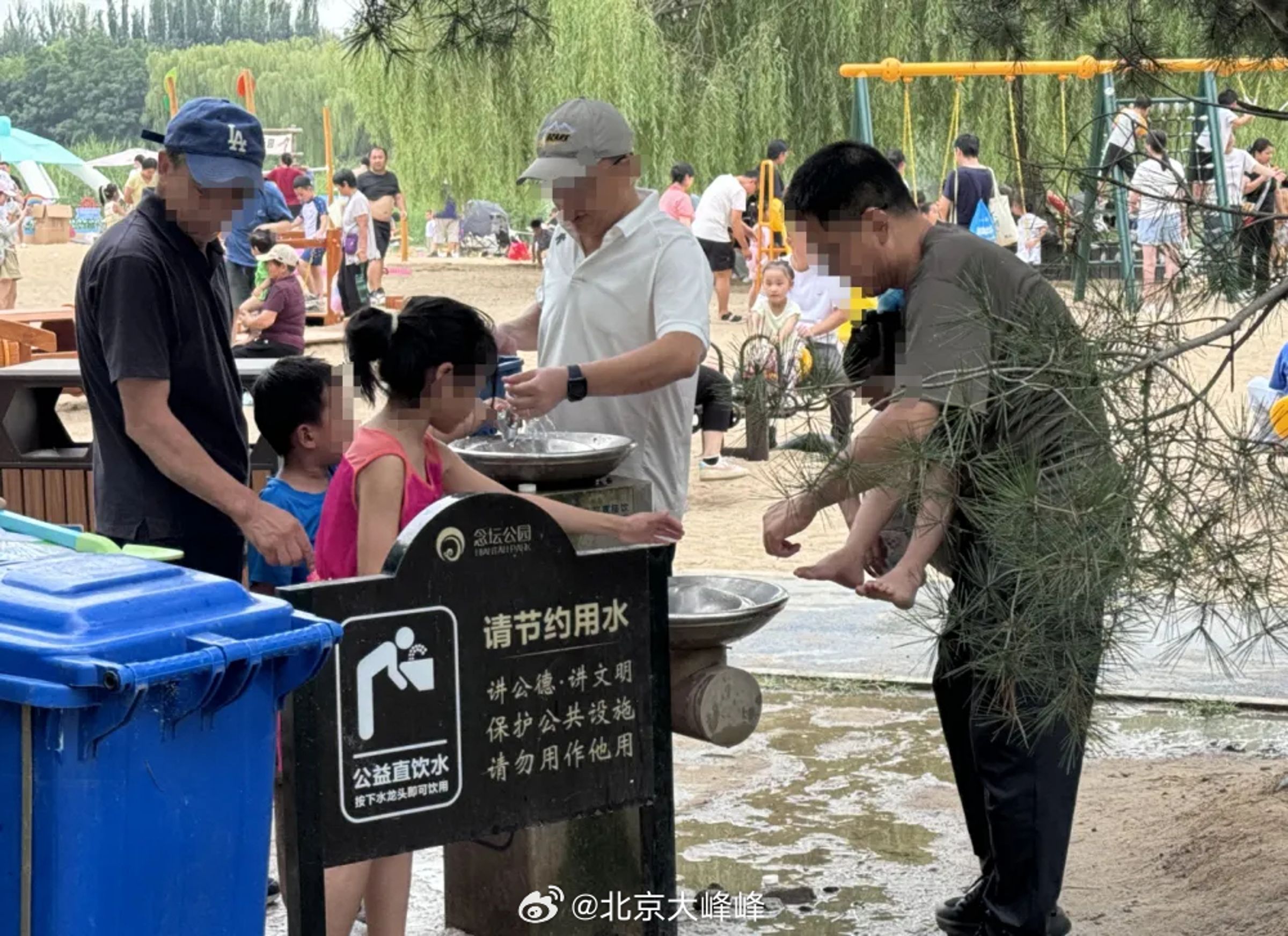 家長濫用北京念壇公園的飲水機,直接抱著小孩幫他洗腳。(翻攝微博)