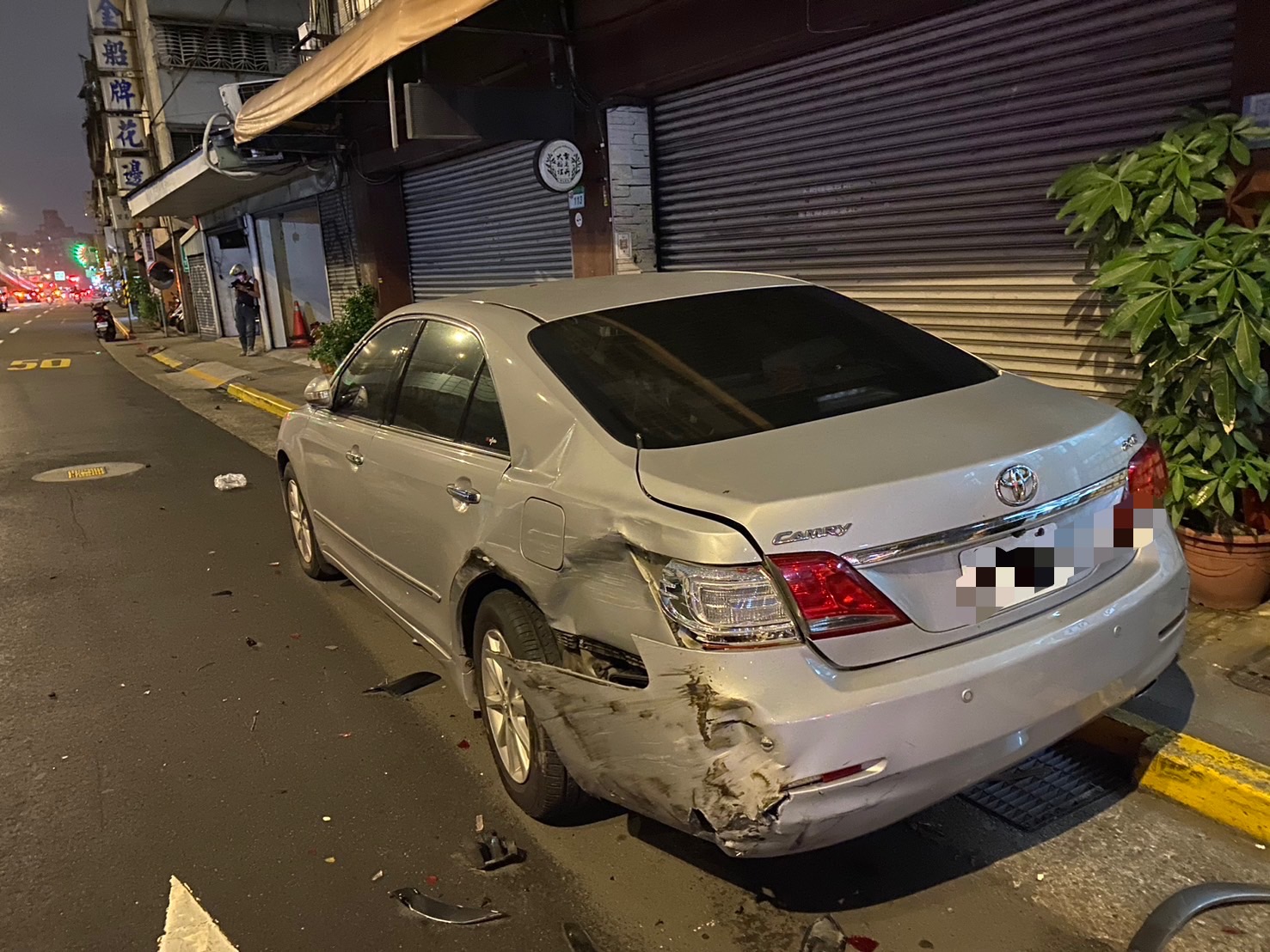 停在路邊無辜挨撞的轎車車尾受損嚴重。(翻攝畫面)