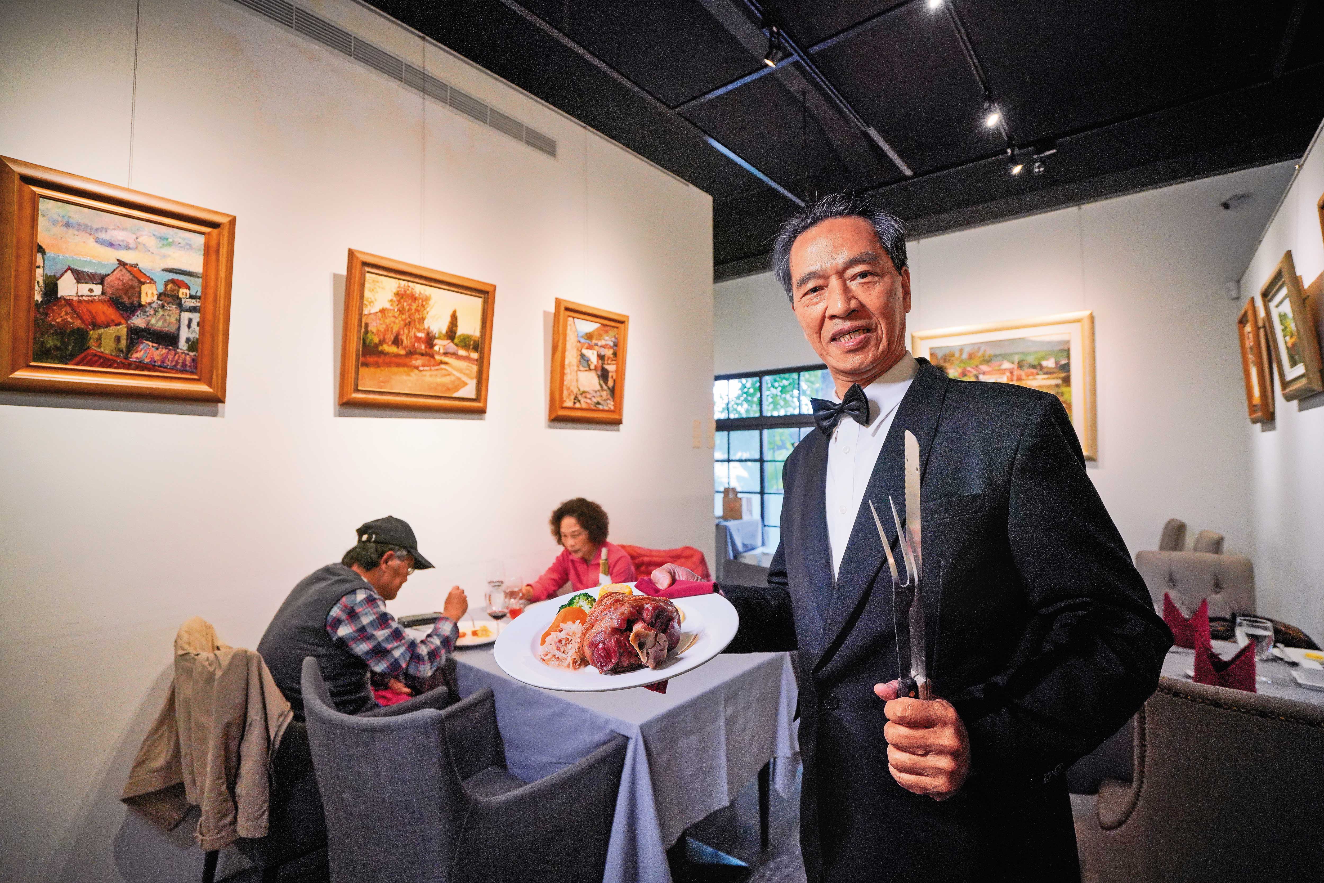 沾美西餐廳老闆陳登壽在近年開設的分店裡端出招牌餐點德國豬腳，並透露繁複的製作過程。