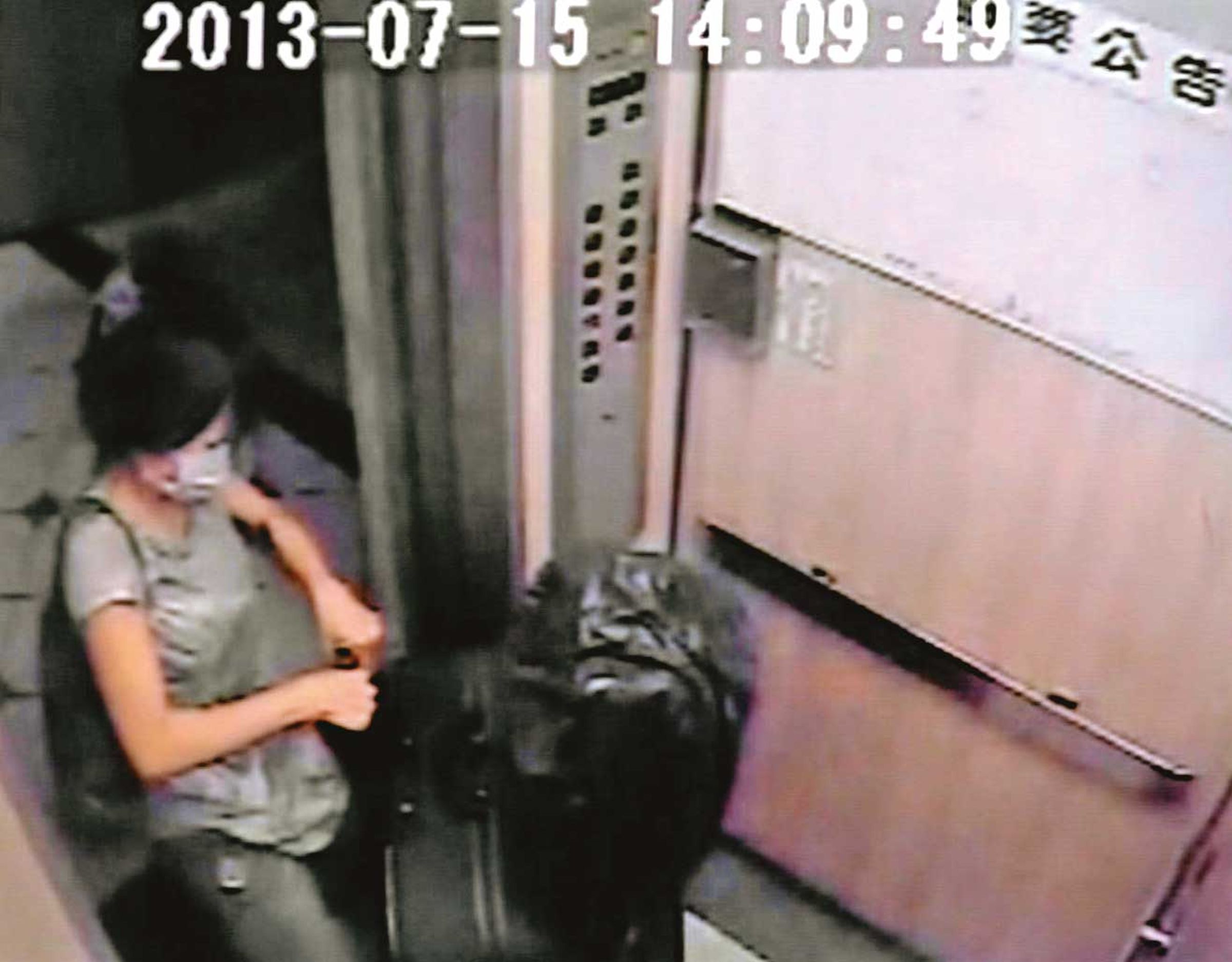 林女拉著沉重的行李箱出門,行李箱內疑似裝著陳男的屍體。(翻攝畫面)