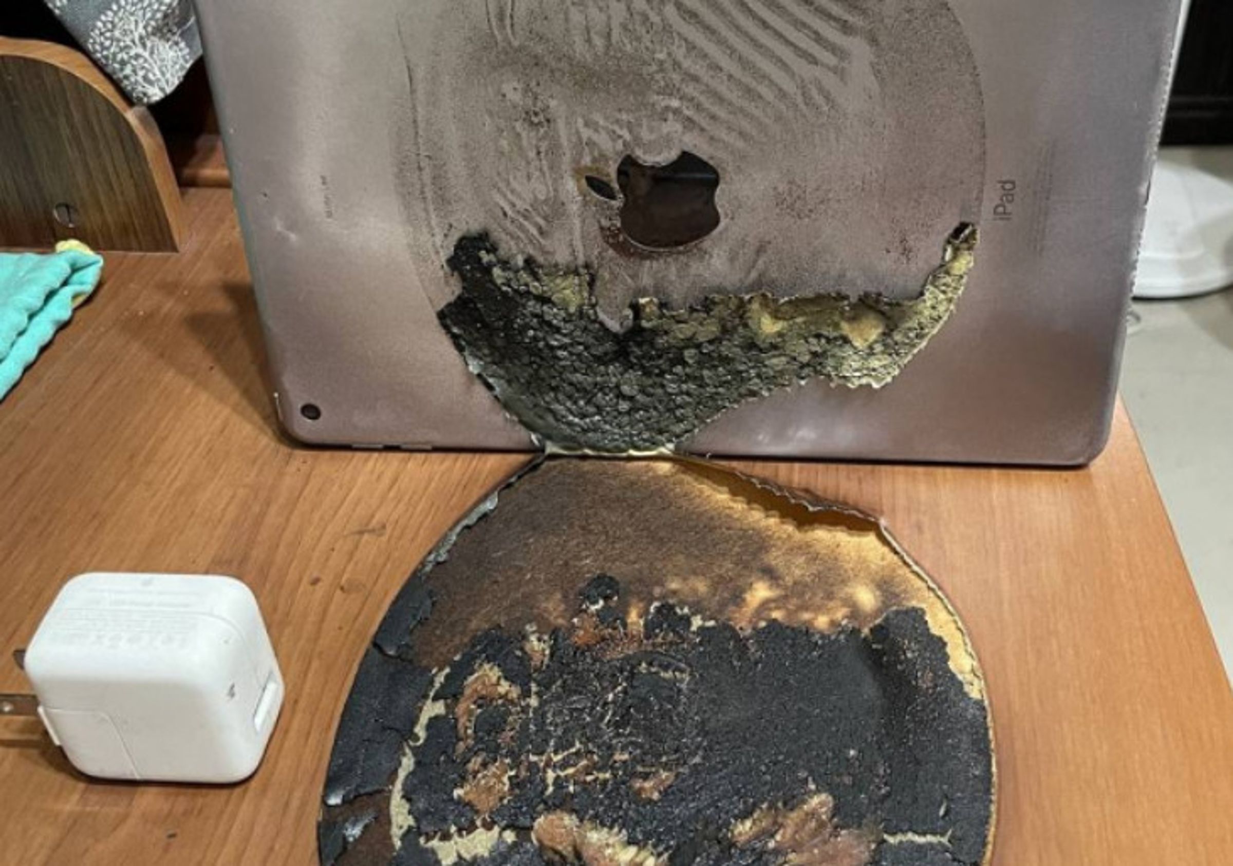 網友透露在家充電iPad 5平板電腦,沒想到居然自燃,將木桌燒出大洞。(翻攝PTT)