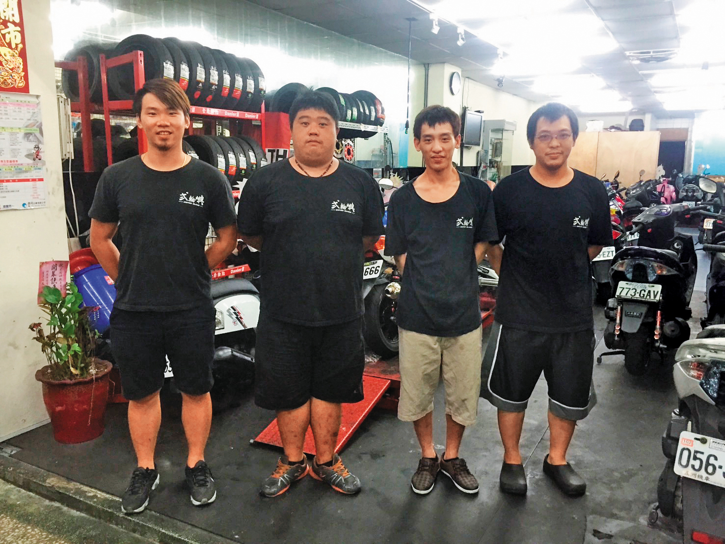 9年前林弘毅（左1）在中和開第一間二手機車店，當時維修、改裝、美容都做，資金有限，店面較小。（林弘毅提供）
