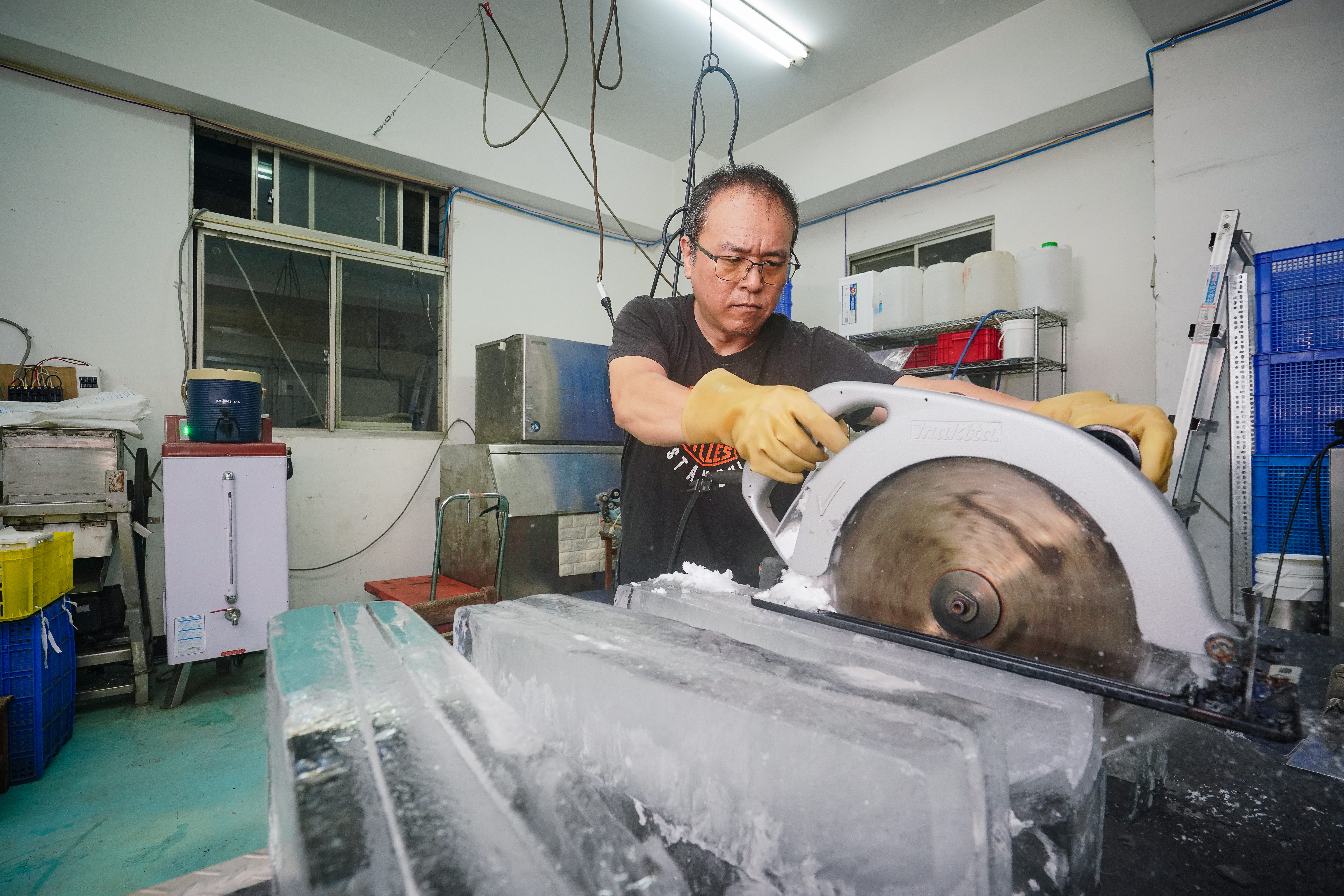 林洲旭將重達150公斤的大冰塊搬到檯面上鋸開、修邊，暑假旺季一天要搬上搬下處理20個，經常沒時間吃飯。