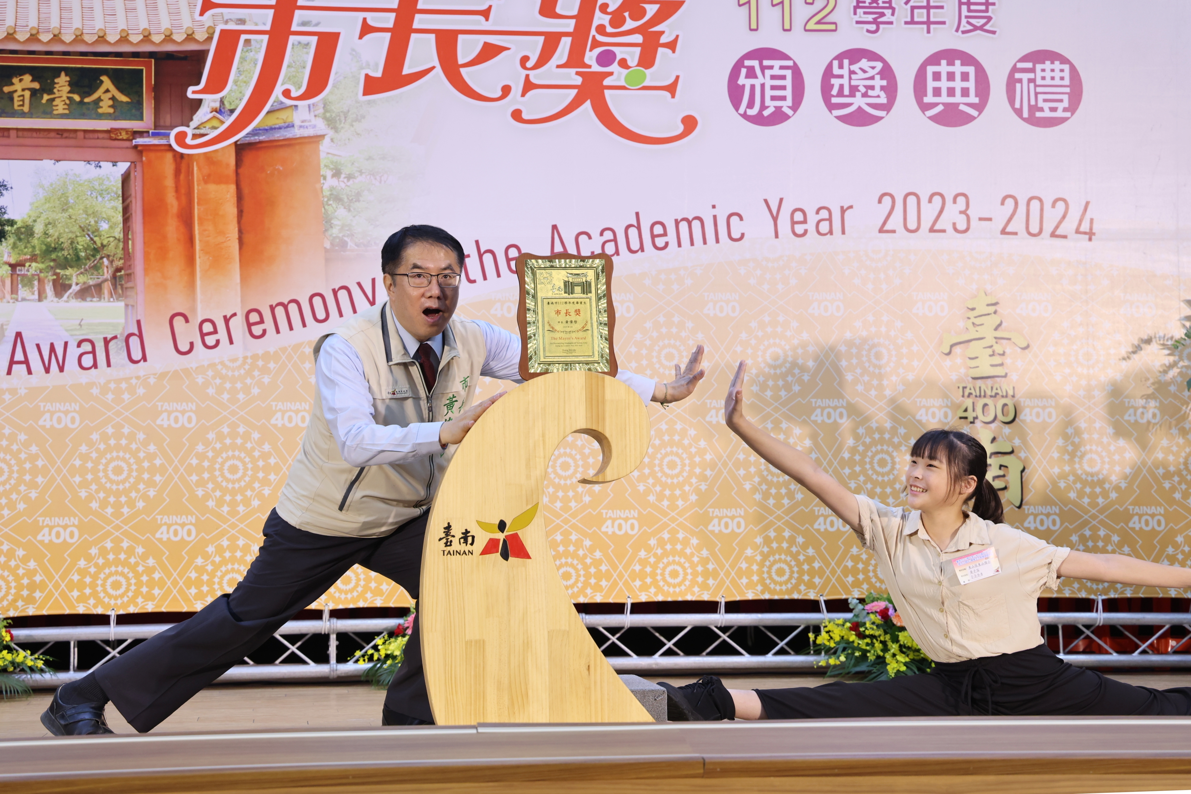 女同學劈腿拉筋和黃偉哲一起拍照留念。（南市府提供）