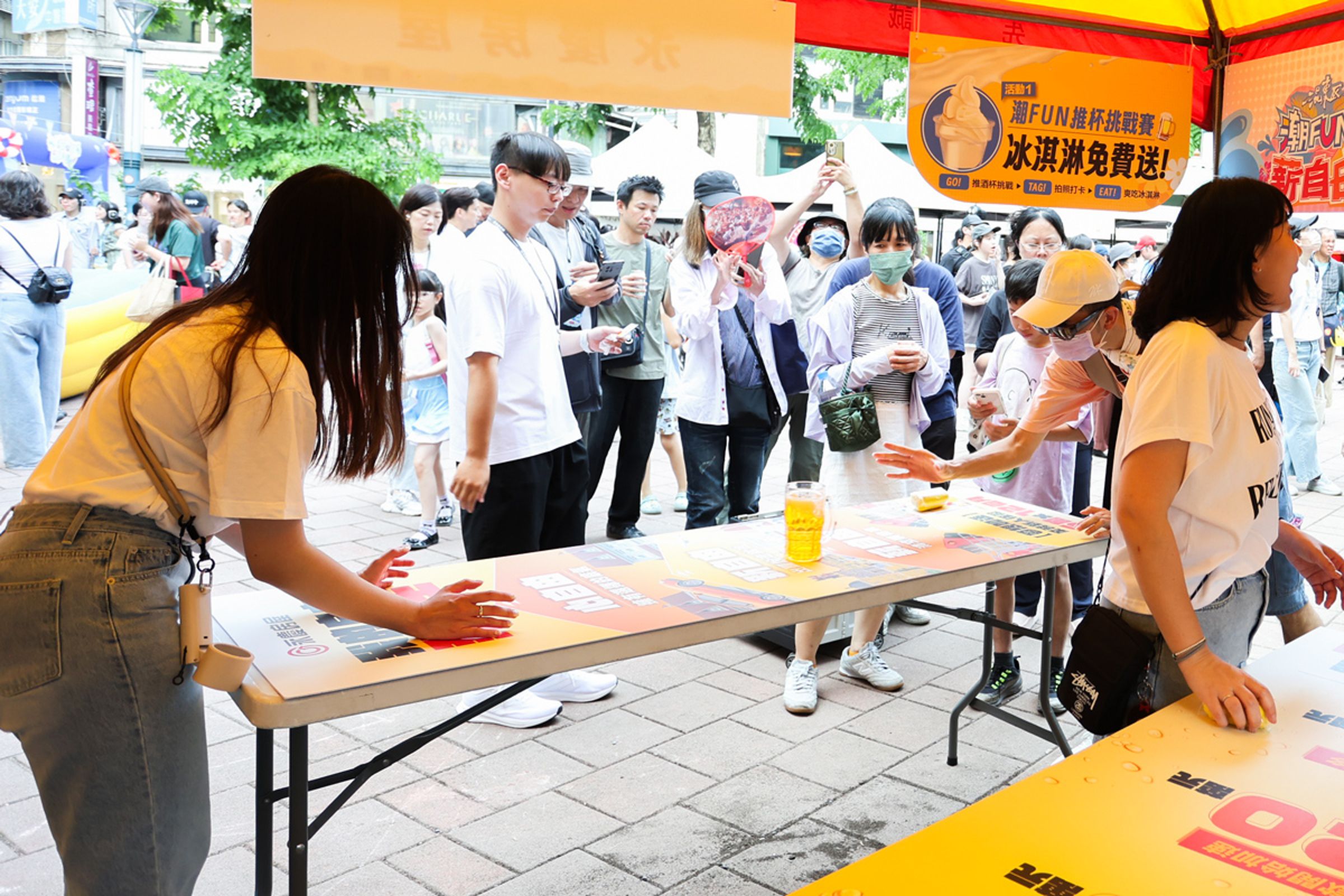 永慶房屋「潮FUN推杯挑戰賽」成熱門攤位，民眾體驗推杯，也進一步詢問房仲工作的收入與發展可能。