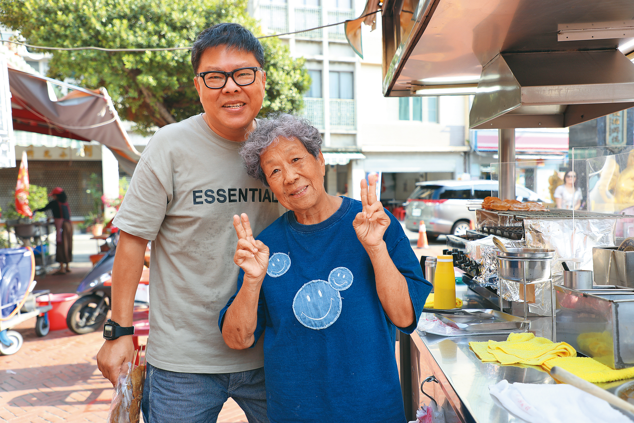 本在台北工作的董育騰（左）現在回家鄉與媽媽阿蘭（右）一同經營小攤，母子倆一個調麵線焿，一個烤黑輪，合作無間。