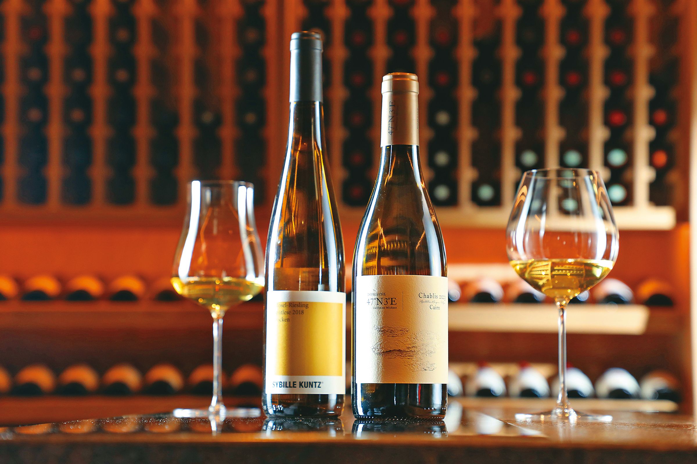 「2023 Chablis, Cairn, 47˚N 3˚E」（右，2,000元／瓶）多汁的熱帶水果香與木質調香氣，能搭配乾煎白鯧魚、白斬雞，展現Chablis的另一種可能；「2018 Mosel, Riesling, Spätlese, Trocken, SYBILLE KUNTZ」（左，2,000元／瓶），撲鼻的花香帶著甜美的柑橘與鳳梨香氣，可試試搭配長年菜、糖醋魚。