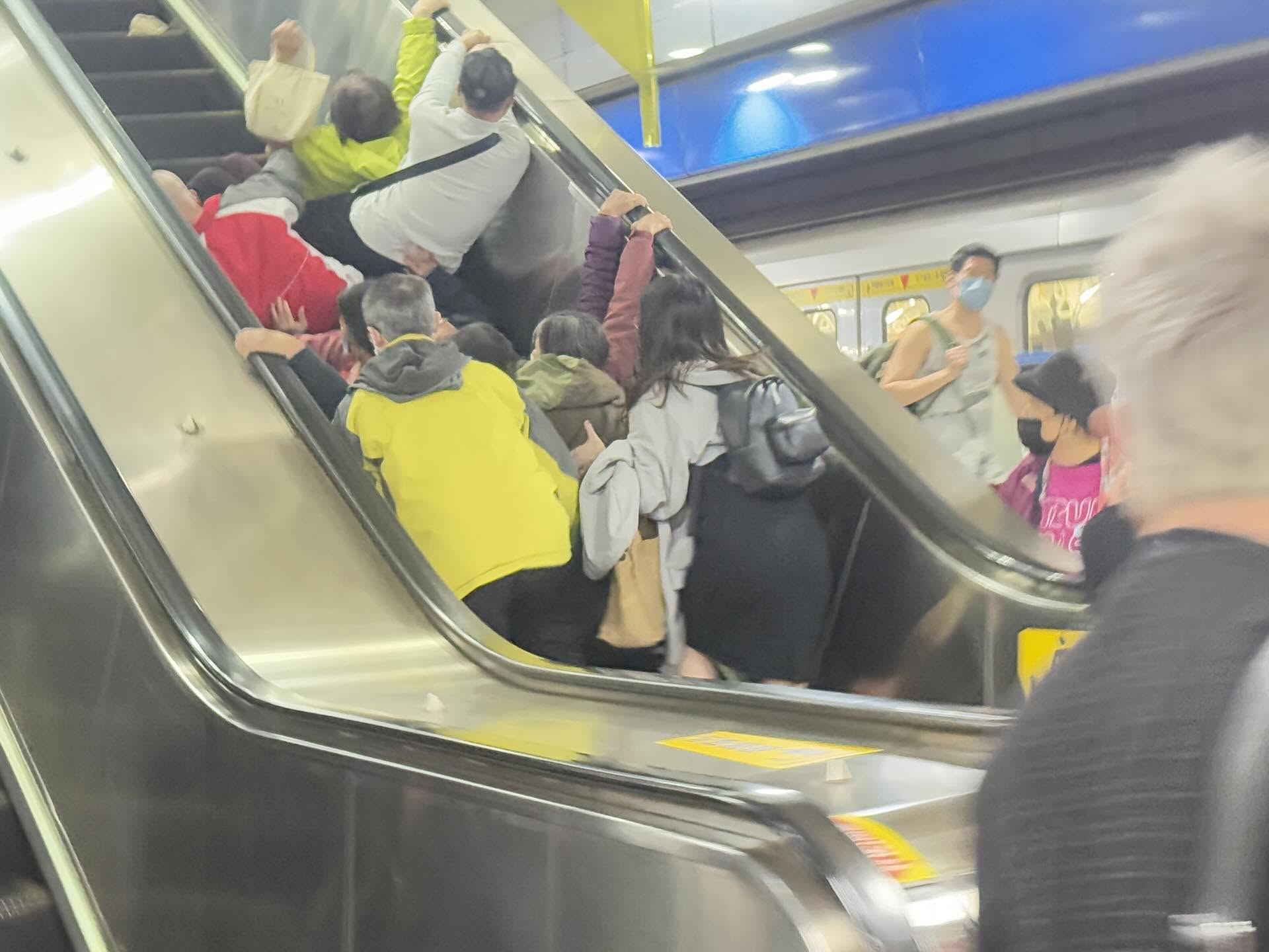 亞東醫院站手扶梯事故現場照片，一名婦人跌倒引發連鎖倒地，熱心乘客及時按下緊急停機按鈕，站長迅速到場協助。（Threads網友dailyhsing授權提供）