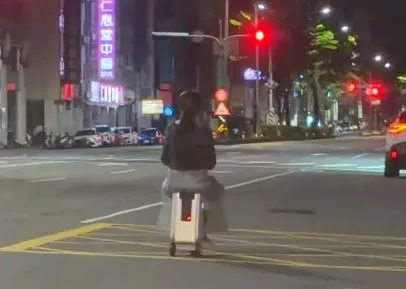 太狂！台中女凌晨4點「悠閒騎行李箱」上中清路　警：違規最高罰3600