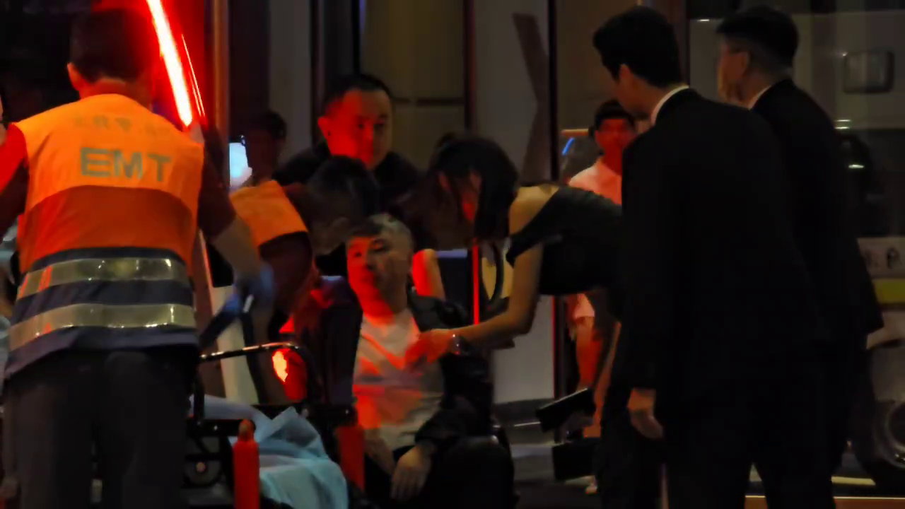詹仁雄被攙扶到救護車前後,被抬上擔架上車送醫。