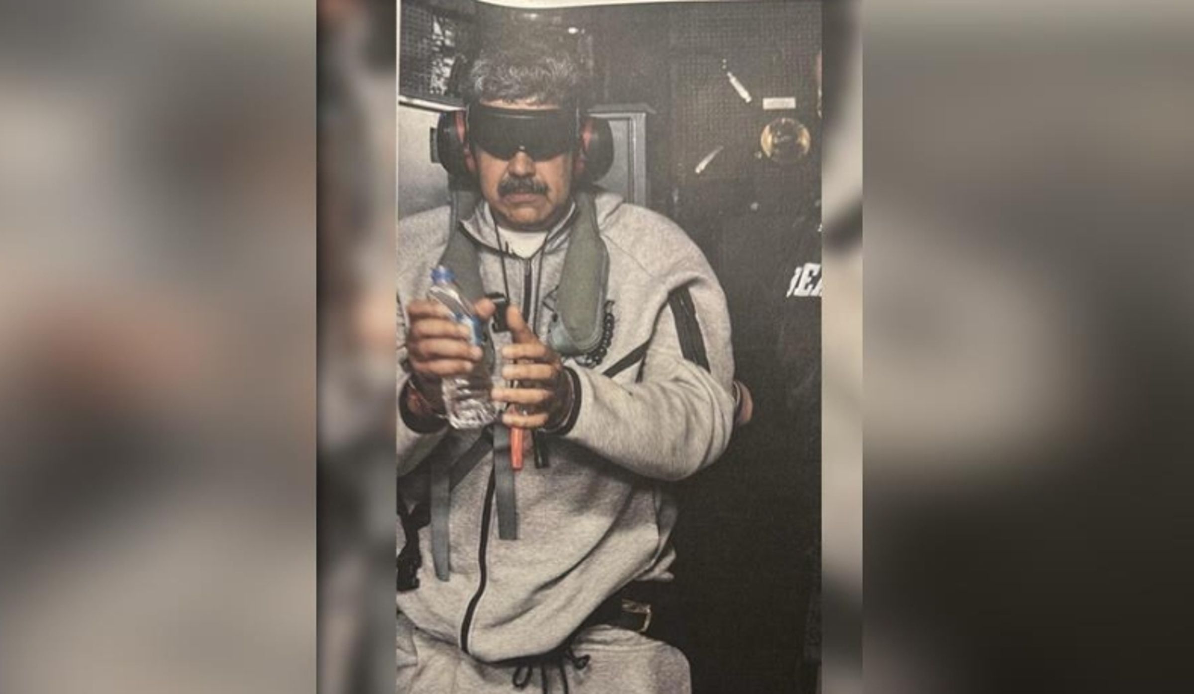 川普公開馬杜洛被拘捕後的畫面,可見其被戴上全黑遮光護目鏡與抗噪耳機,身後疑似DEA人員隨行,引發各界高度關注。(翻攝自Truth Social)