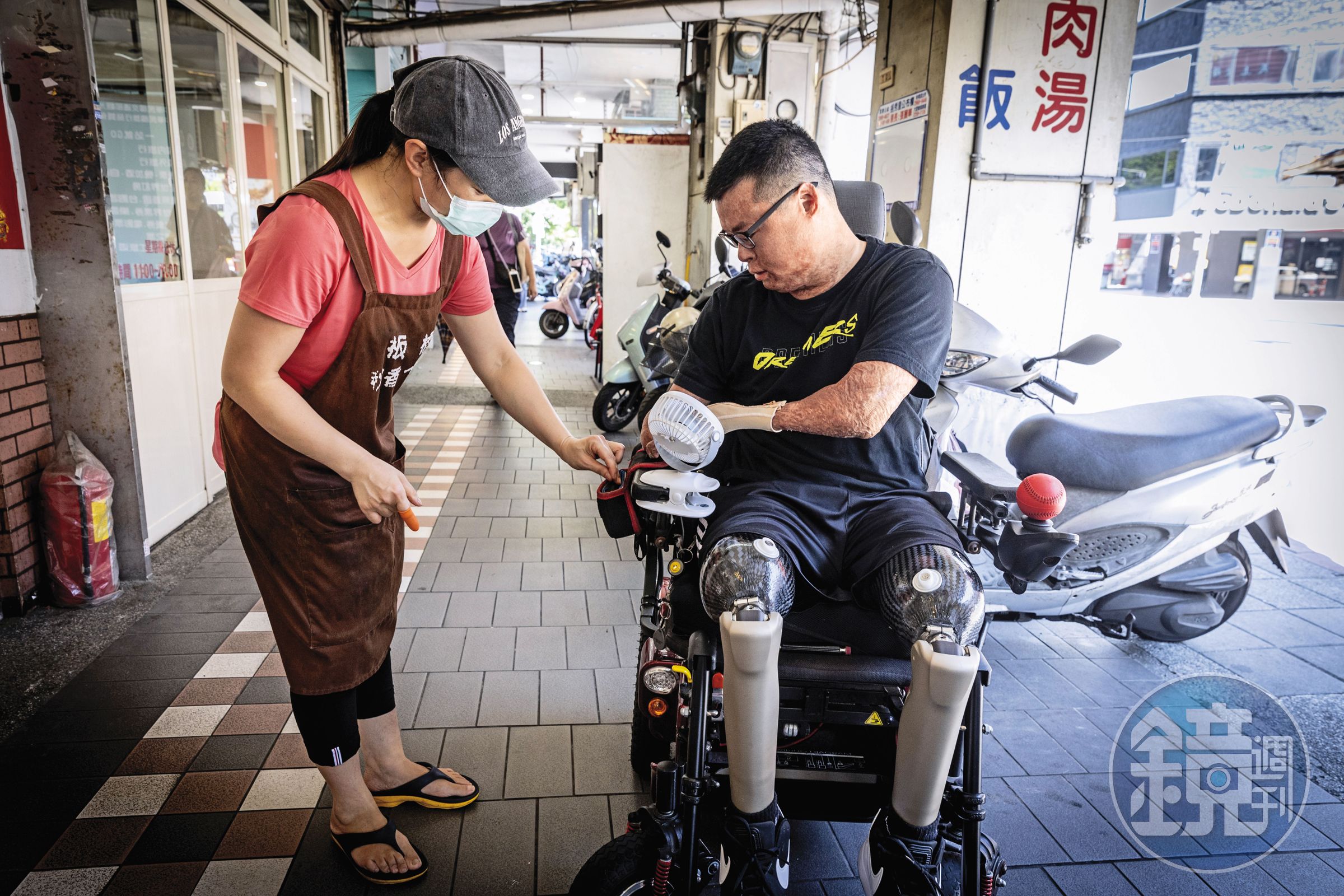 黃博煒（右）和經常光顧的小吃店家老闆（左），共同建立了付費找錢的SOP，2人談笑就像街坊好友。