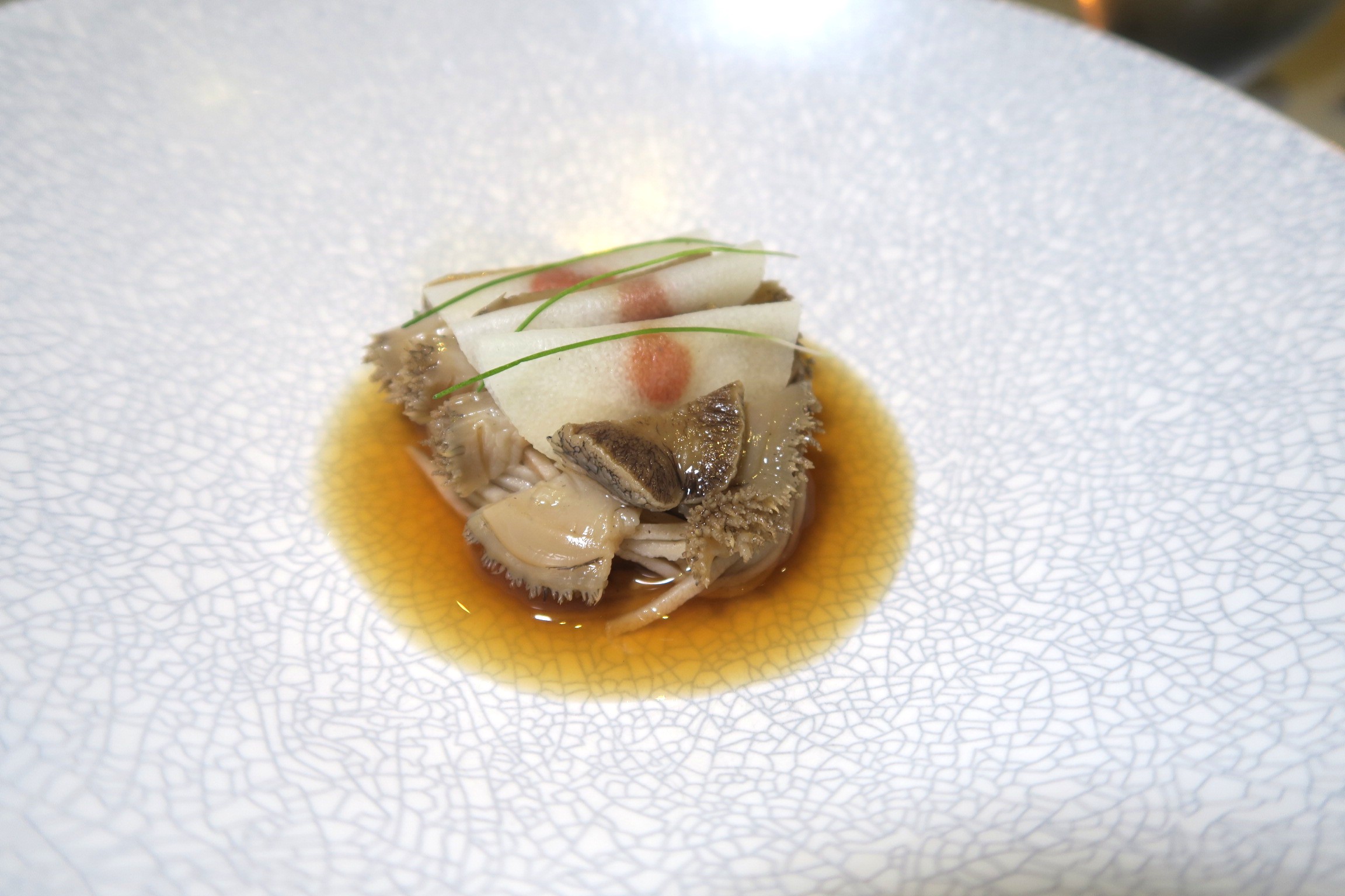 蕎麥麵上覆蓋以清酒、燒酒、紹興酒慢煮12小時的鮑魚,上頭鋪了切得極薄的筍片,裡頭還包夾枸杞,呼應最後淋上的鮑魚枸杞高湯。