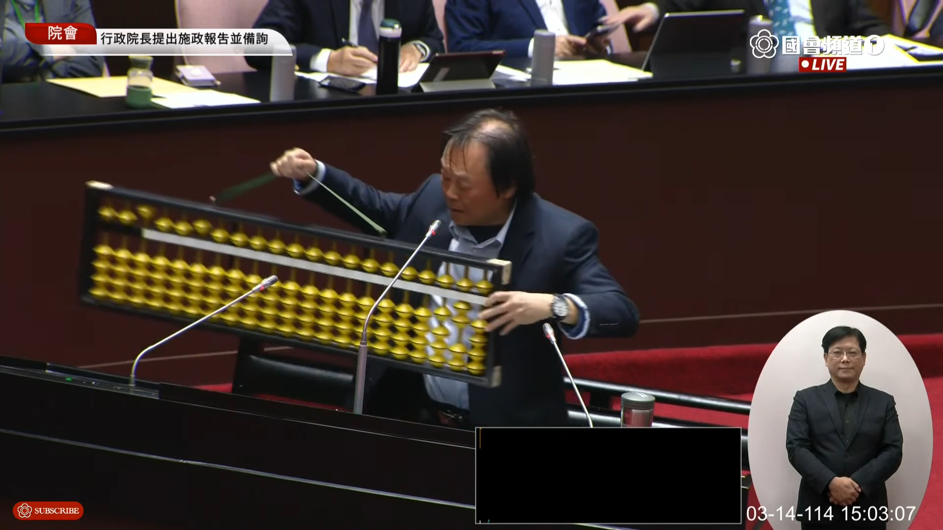 王世堅的超大算盤，看起來很重。（翻攝國會頻道）