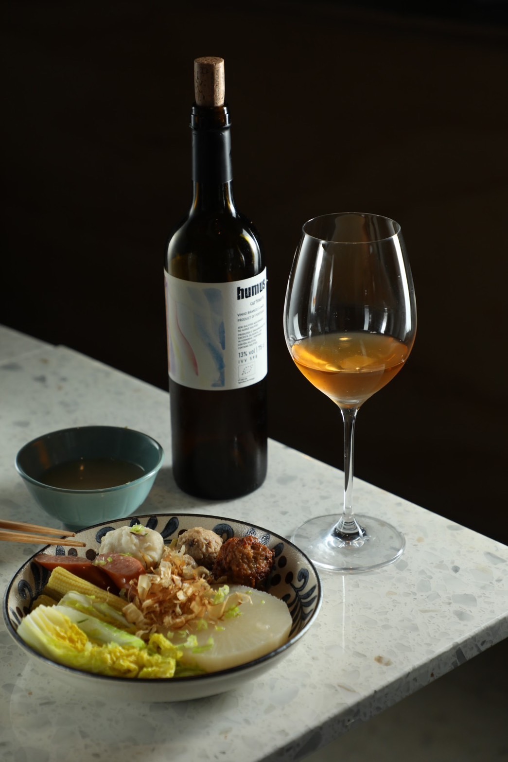 洋溢新鮮柑橘、桃子與蘋果風味的橘酒「Curtimenta」（300元／杯，1,500元／支）和湯頭鮮潤的台式「關東煮」（依單品計價，圖中約為200元）作夥，溫柔襯出彼此風味。