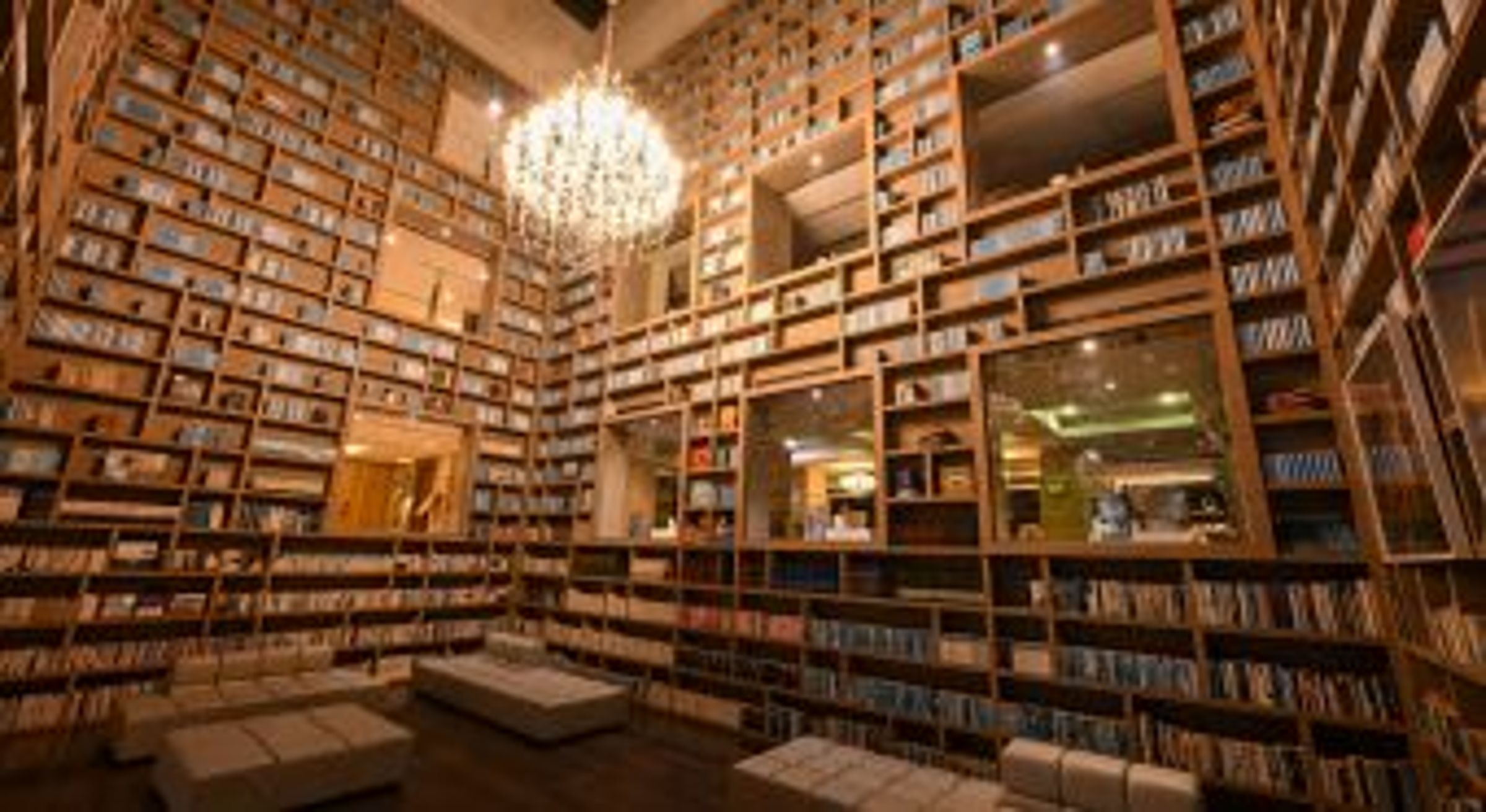 北投大地酒店光陰部落藏書閣，挑高四樓的環景書牆，二十二層書架，藏書六千本書。（大地酒店提供）