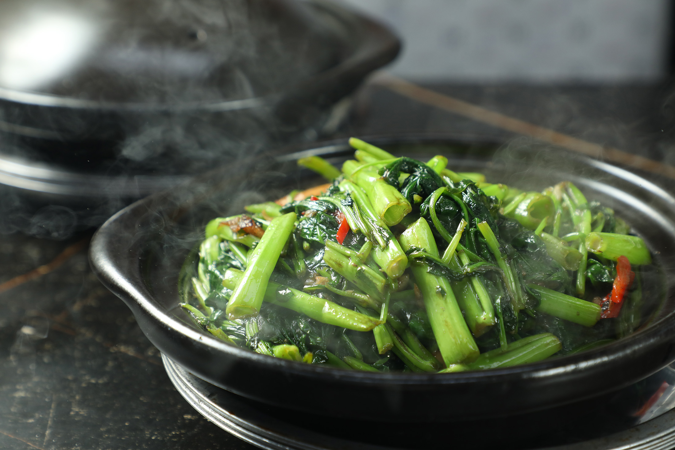 「啫啫通菜煲」完美呈現空心菜的爽脆與焦香，加入肉碎與豆豉醬後，鹹香濃郁，甚至比肉煲更令人驚豔。（港幣90元／份，約NT$347）