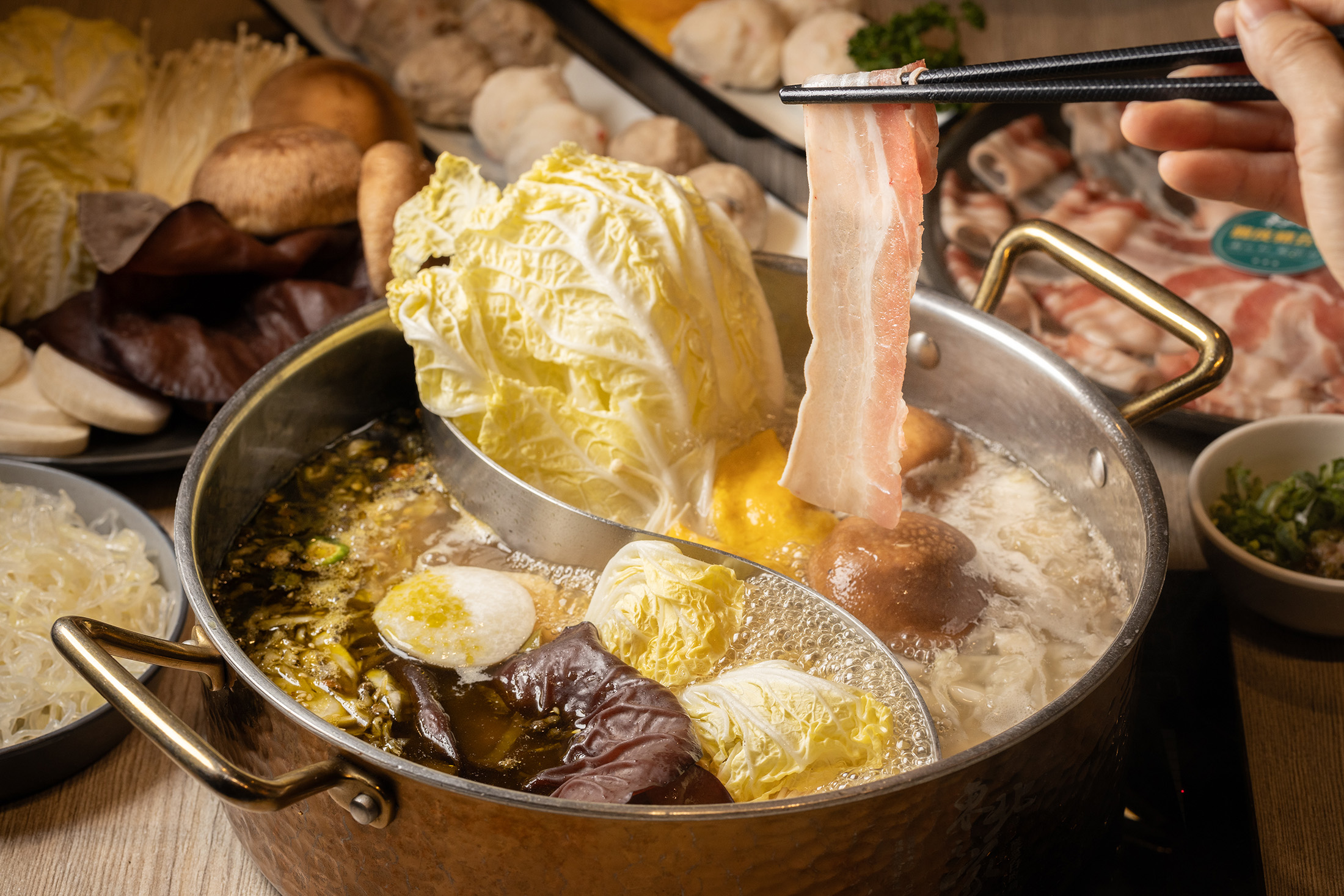 「東北之家酸菜白肉鍋」的酸菜湯底喝來酸香爽口，加入大白菜與菇類等菜品更顯美味。（外帶火鍋組1,198元／組、約4～6人份）