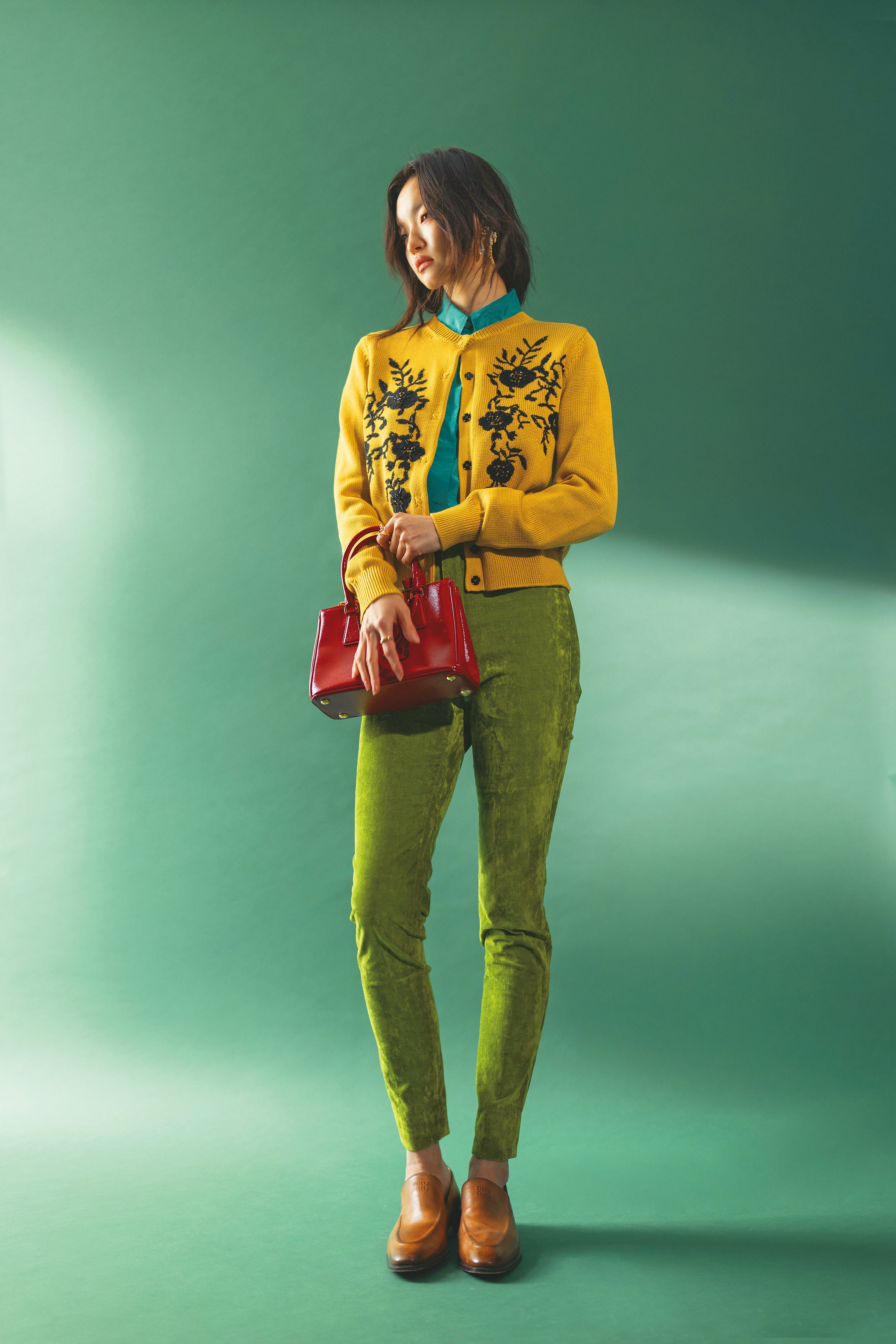 芥末黃花卉刺繡上衣 NT$16,700 by MAX&Co. ；淺藍色真絲塔夫綢襯衫 NT$53,200 by FENDI；草綠色絨布彈性窄管褲 NT$44,500 by GUCCI；咖啡色皮鞋 NT$38,000 by MIU MIU；紅色包款 價格店洽 by PRADA；海馬造型耳環 NT$62,300 by GUCCI；（右）自然流線心形戒指 NT$4,080 by PANDORA；（左）自然流線疊戴戒指 NT$5,280 by PANDORA。