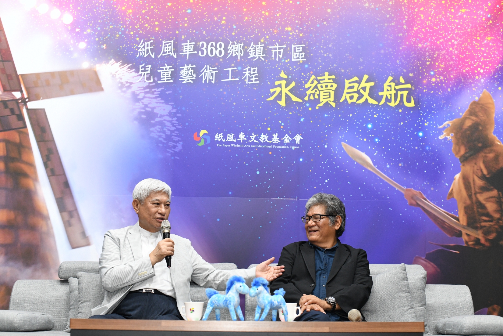 陳進財董事長(左)笑說第一次看到李永豐創辦人時,覺得這個人很粗魯,但做著很偉大的事情。(紙風車文教基金會提供)