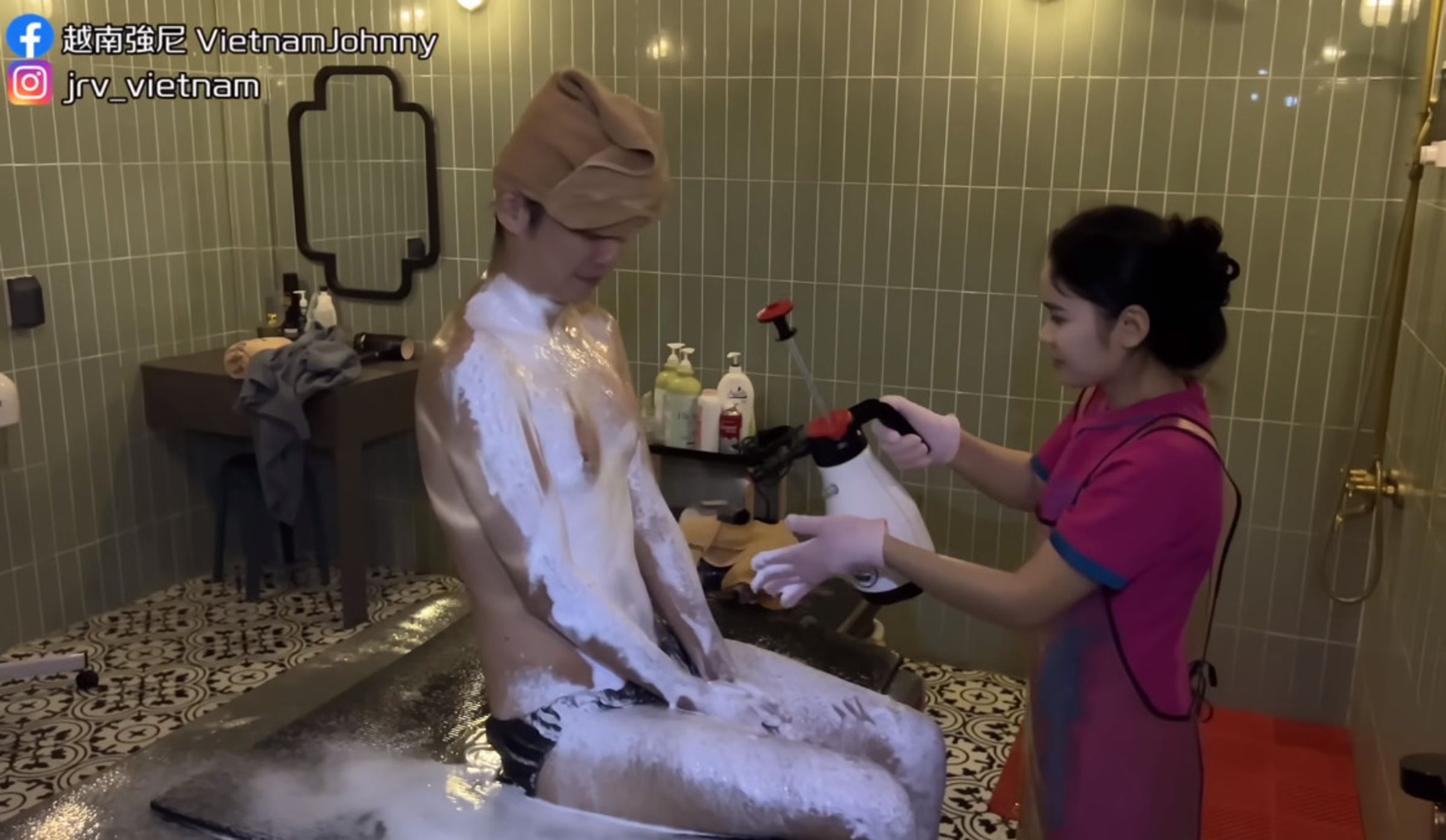 服務人員拿噴霧器在強尼全身噴上泡沫。(翻攝自YT頻道「越南強尼VietnamJohnny」)