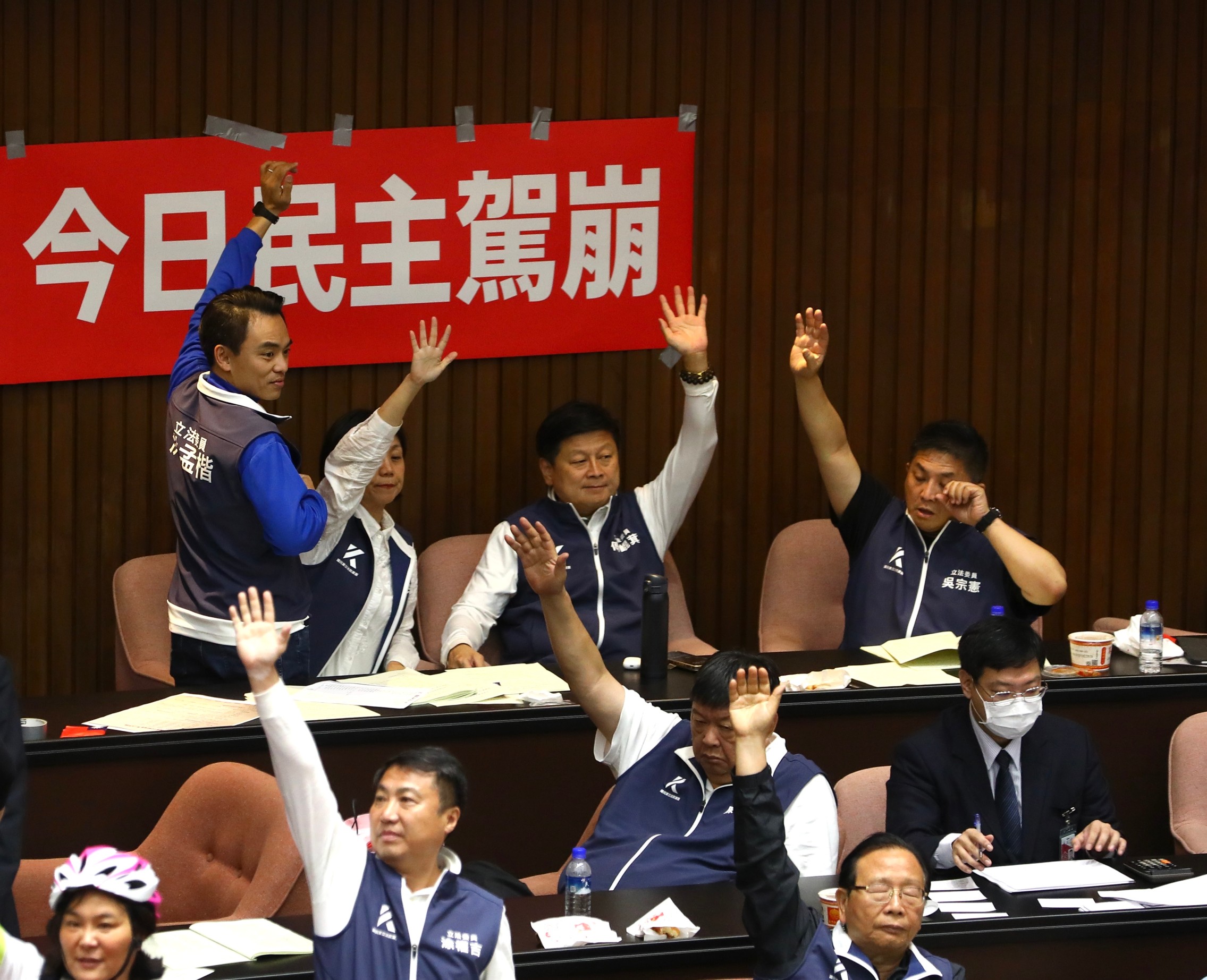 藍委們坐在「今日民主駕崩」的布條前舉手表決。